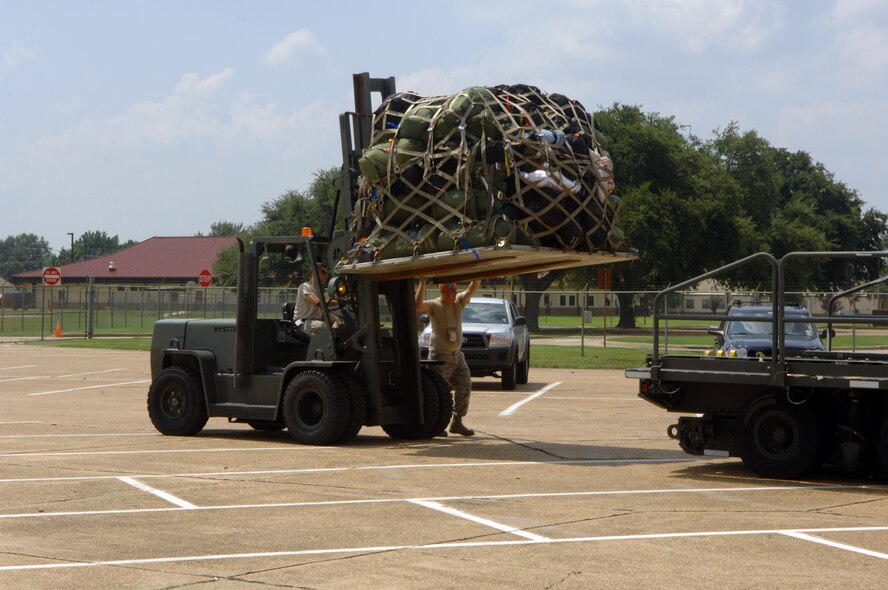 BARKSDSALE AIR FORCE BASE, La. -- Air Force Tech. Sgt. Chandler Thomas (walking) and Senior Airman Joshua Hrnciar (driving), of the 2d Logistics Readiness Squadron, load a pallet of equipment onto a k-loader in the parking lot of Hoban Hall here Aug. 30. Airmen from Barksdale responded to a request to support a short-notice deployment of the 1083rd Transportation Company from Minden. The 1083rd went to south Louisiana in anticipation of Hurricane Gustav making landfall there. (U.S. Air Force photo by Staff Sgt. Mike Andriacco) (Released)