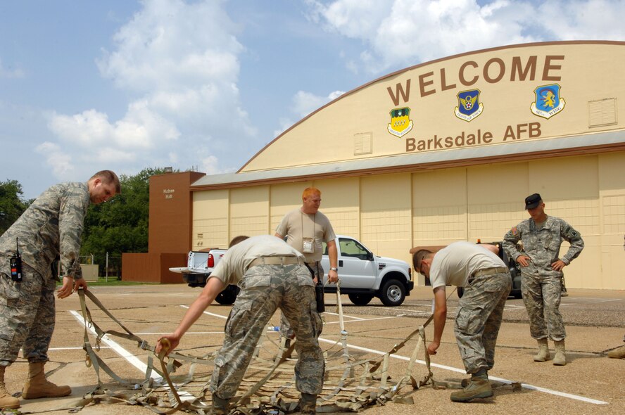 BARKSDSALE AIR FORCE BASE, La. -- Air Force 1st Lt. Nicholas Lee, Tech Sgt. Chandler Thomas, Senior Airman Joshua Hrnciar and Senior Airman Darrell Fenimore Jr., all from the 2d Logistics Readiness Squadron, prepare a cargo net to go over a pallet of equipment in the parking lot of Hoban Hall here Aug. 30. The Airmen built pallets to support a short-notice deployment of the 1083rd Transportation Company from Minden. They went to south Louisiana in anticipation of Hurricane Gustav making landfall there. (U.S. Air Force photo by Staff Sgt. Mike Andriacco) (Released)