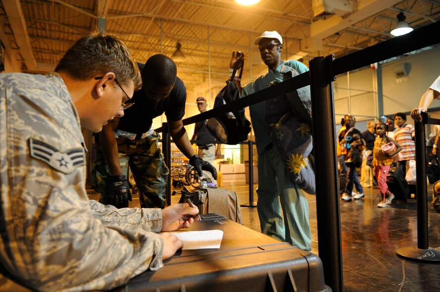 Senior Airman Robert Haog and Staff Sgt. Adam White weigh luggage as evacuees of Hurricane Gustav arrive at the Louis Armstrong International Airport, New Orleans, La., Aug. 30.  Evacuees arrived at the airport to board flights the Federal Emergency Management Agency and Department of Defense chartered to transport citizens who otherwise could not leave on their own to destinations safely outside the hurricane's path.  The Airmen are both assigned to the 573rd Global Support Squadron, 615th Contingency Response Wing, from Travis Air Force Base, Calif.  Airmen assigned to the 615th CRW deployed to the Gulf Coast region to establish airfield operations in support of the hurricane evacuation effort.  (U.S. Air Force photo by Staff Sgt. Shawn Weismiller)