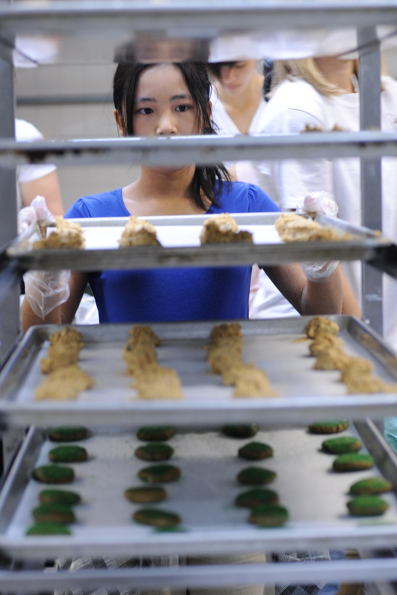 Christine Comia, a member of the National Honor Society from Kadena High School, prepares to bake a batch of cookies Nov. 19 at the 18th Force Support Squadron's central kitchen on Kadena Air Base, Japan. Volunteers prepared more than 24,000 cookies that will be delivered to servicemembers living in the dorms here at Kadena. (U.S. Air Force photo/Airman 1st Class Chad Warren)