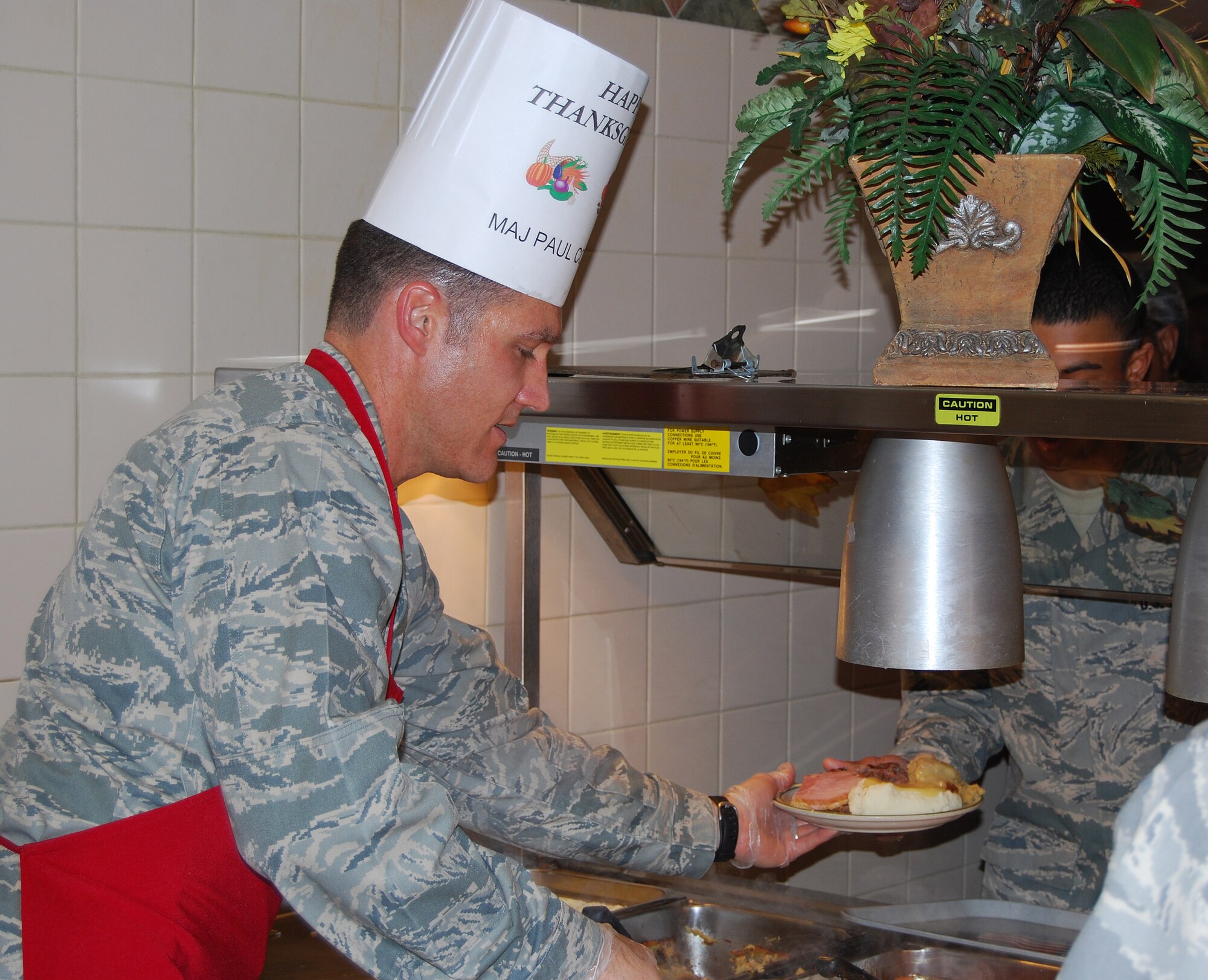 Maj. Paul Corman, 365th Training Squadron Director of Operations, serves Thanksgiving meals to Sheppard Airmen Nov. 27. Many Sheppard officers and senior enlisted members manned all of the food stations at the Sagebrush Dining Facility in this year's event. (U.S. Air Force photo/Staff Sgt. Vernon Cunningham)