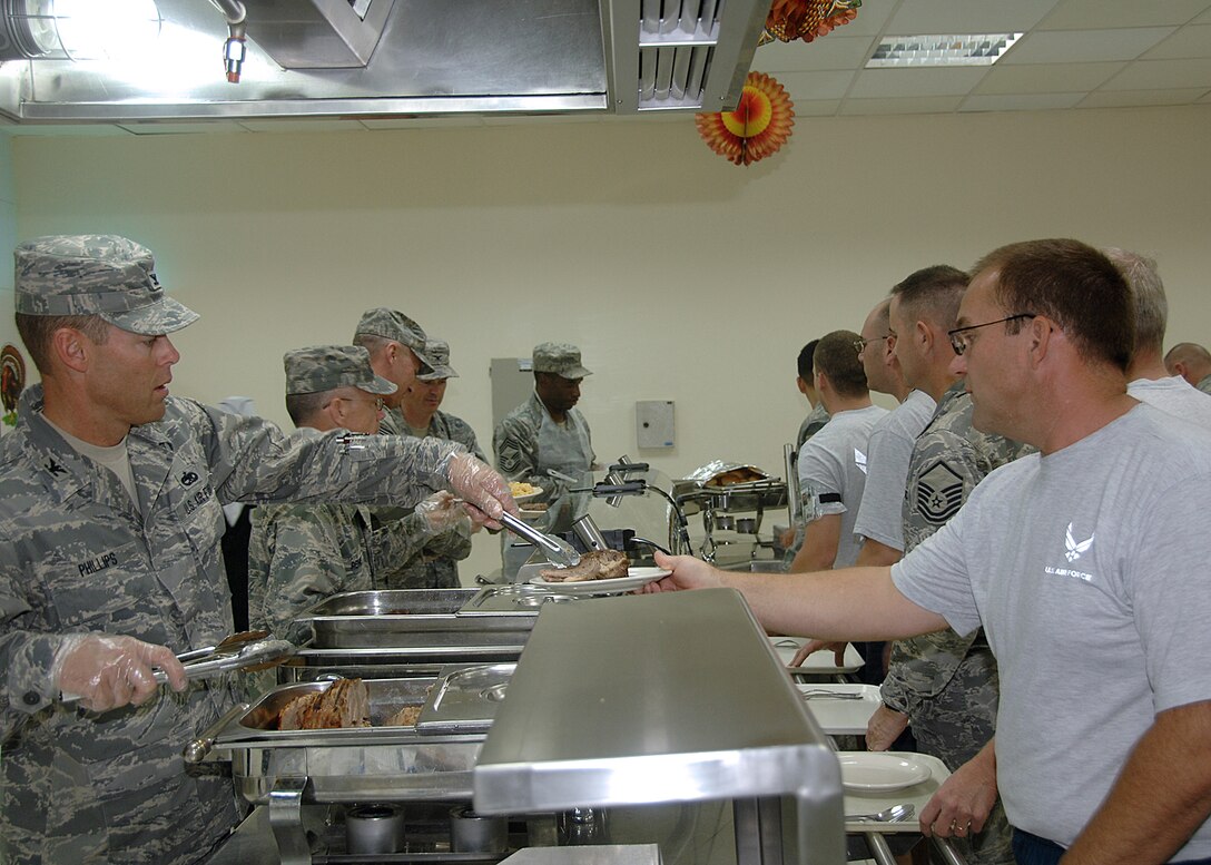 Southwest Asia:  TSgt Ingo Shultz of the Happy Hooligans gets served his Thanksgiving meal by Col Phillips while on assignment with the 386th Expeditionary Civil Engineering Squadron.

 

