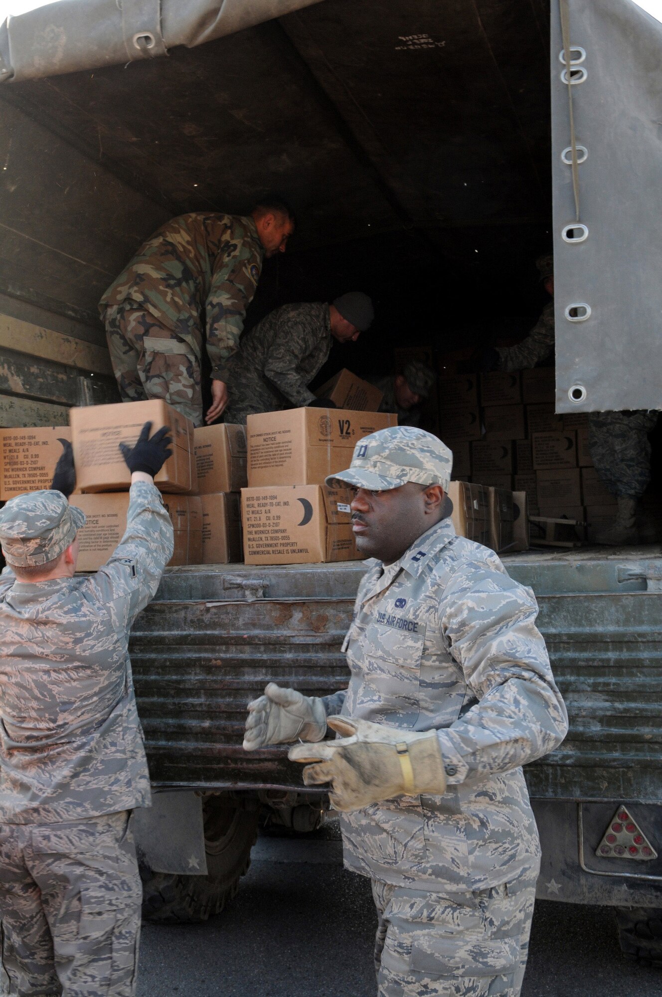 Airmen at Manas Air Base, Kyrgyzstan, work with Kyrgyz military representatives from the Ministry of Emergency Situations to load donated meals-ready-to-eat following a humanitarian assistance ceremony at the base Nov. 25. Department of Defense officials donated MREs and cold weather sleeping bags to help local Kyrgyz who may need assistance during the coming winter. (Air Force photo/Senior Airman Ruth Holcomb)