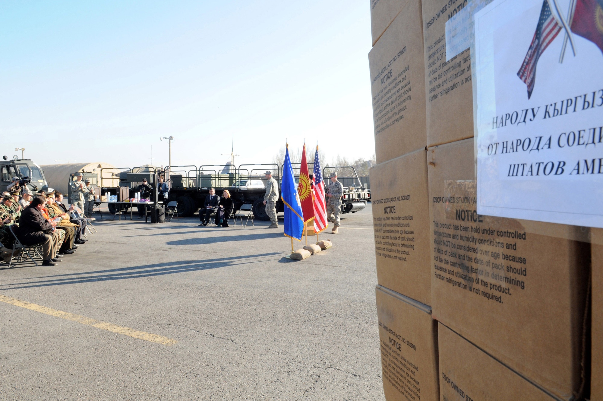 Airmen at Manas Air Base, Kyrgyzstan, and representatives from the U.S. Embassy and Kyrgyz Republic Ministry of Emergency Situations attend a humanitarian assistance ceremony at the base Nov. 25.  Following the ceremony, the Airmen and Kyrgyz military representatives loaded meals-ready-to-eat and cold-weather sleeping bags donated by Department of Defense officials on to ministry trucks.  The supplies are to help local Kyrgyz who may need assistance during the coming winter. (Air Force photo/Senior Airman Ruth Holcomb) 