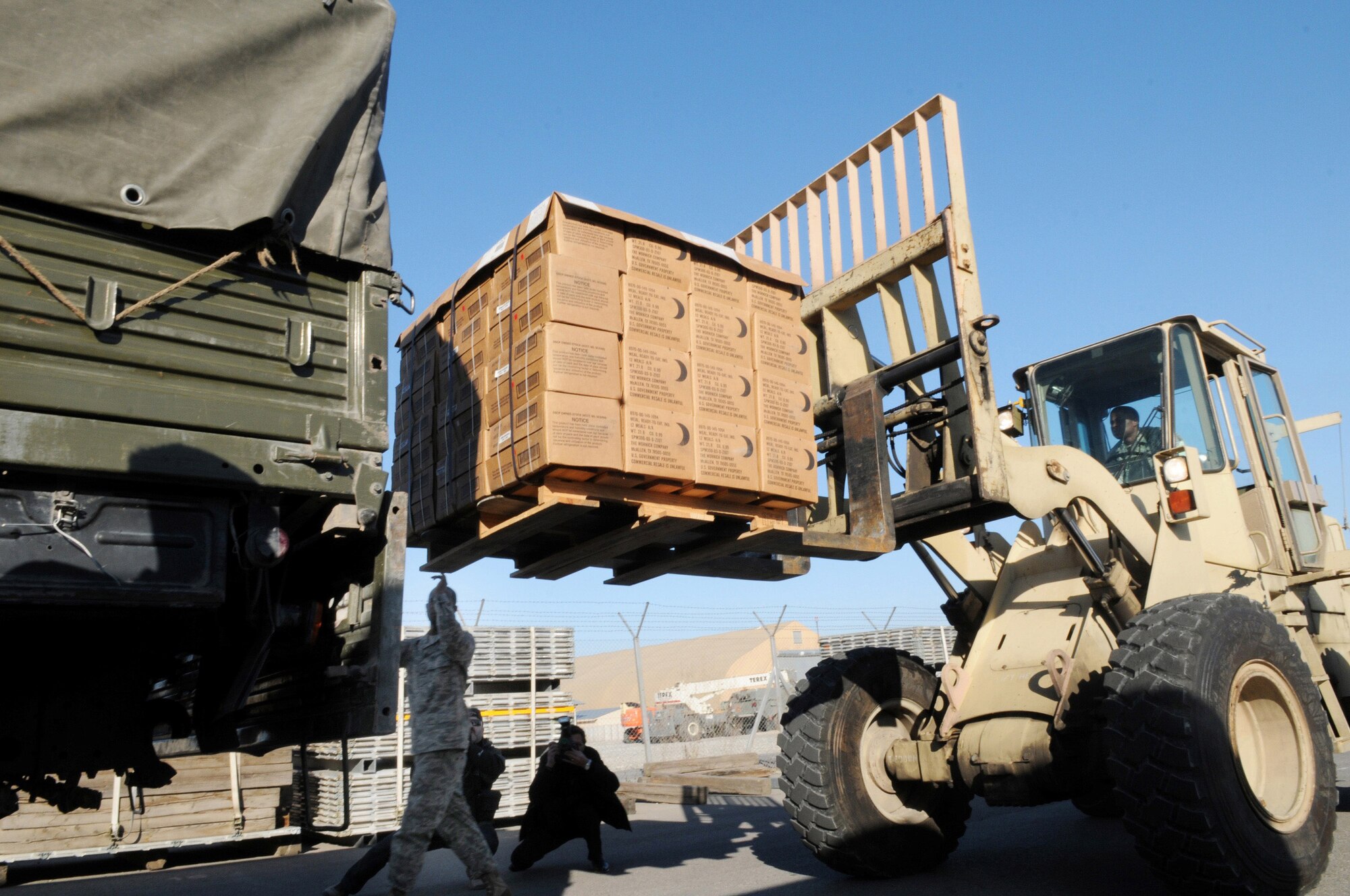 Airmen at Manas Air Base, Kyrgyzstan, work with Kyrgyz military representatives from the Ministry of Emergency Situations to load donated meals-ready-to-eat following a humanitarian assistance ceremony at the base Nov. 25. Department of Defense officials donated MREs and cold weather sleeping bags to help local Kyrgyz who may need assistance during the coming winter. (Air Force photo/Senior Airman Ruth Holcomb)