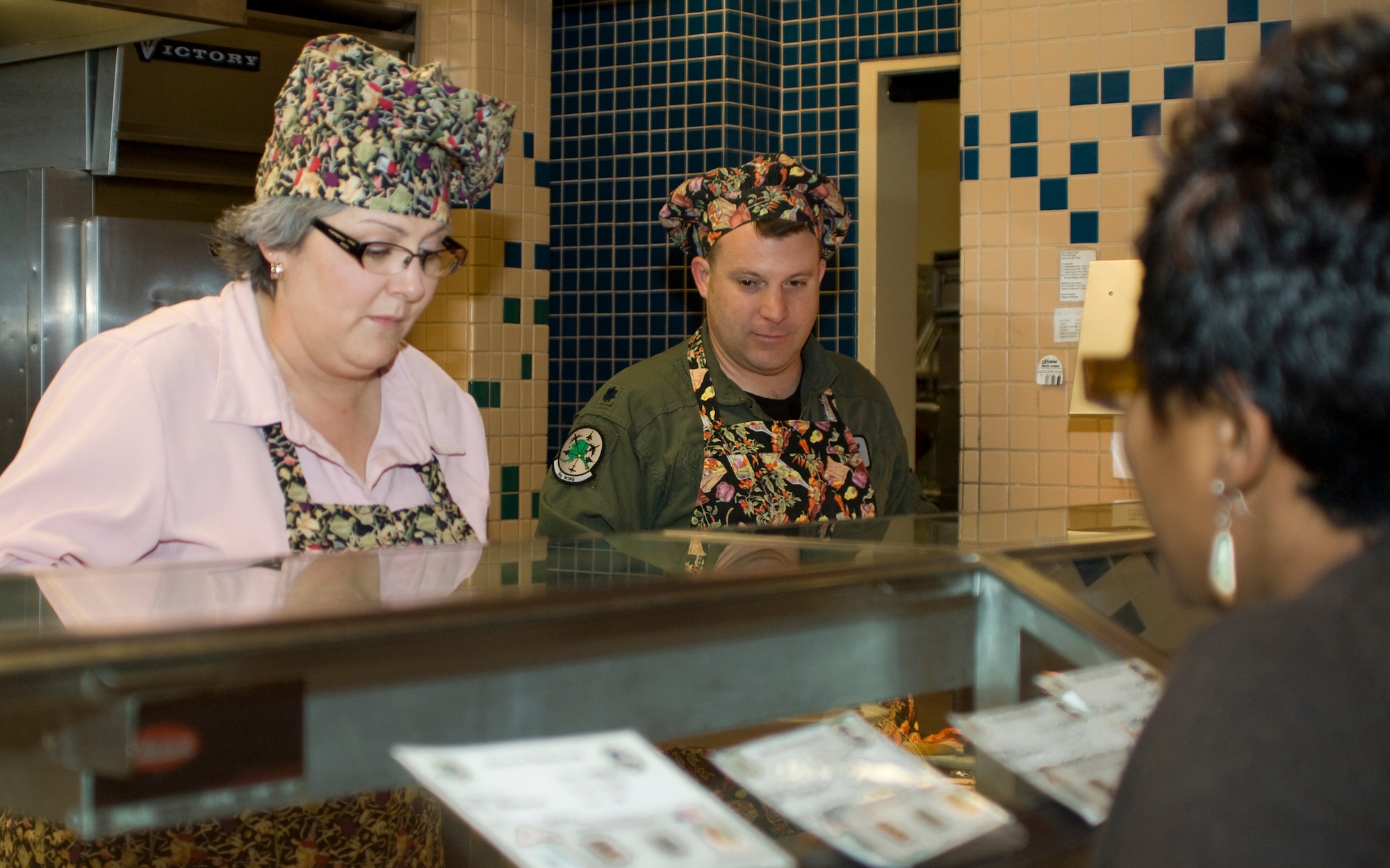 ELMENDORF AIR FORCE BASE, Alaska -- Cathy Grossman, 3rd Mission Support Group, and Lt. Col. Kevin Brown, 3rd Operations Group, serve a plate to a customer at the Iditarod Dining Facility Nov. 27. Several members of Elmendorf leadership served food to the Iditarod customers. Nearly 330 people were served during the lunch-time meal at the dining facility. (U.S. Air Force photo/Airman 1st Class David Carbajal)