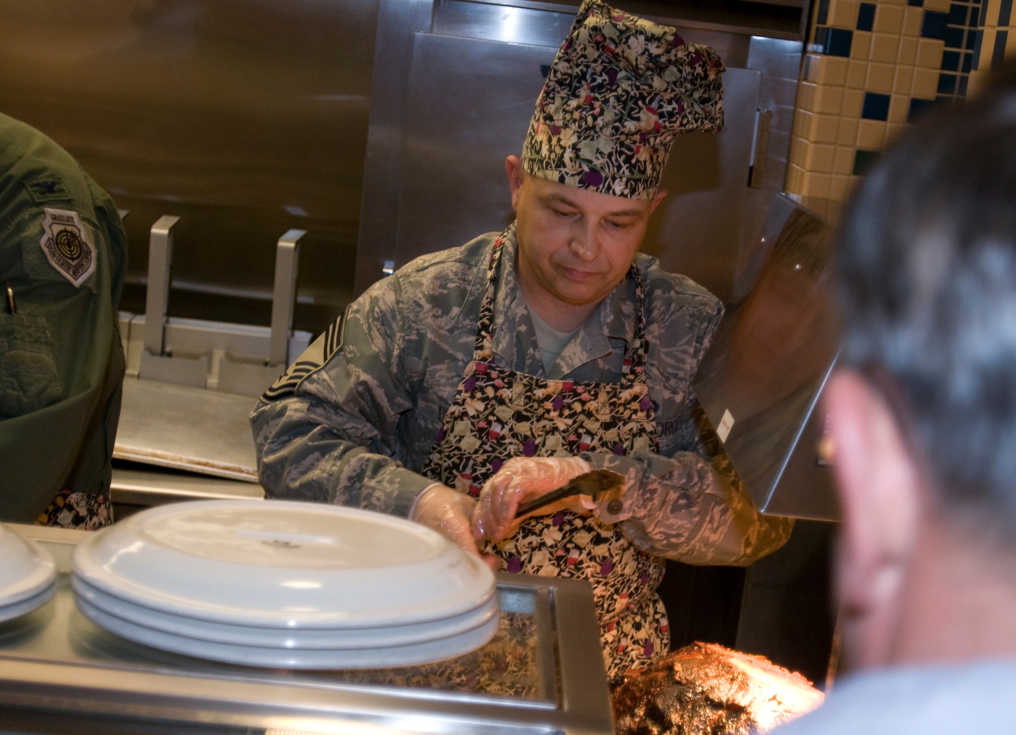 ELMENDORF AIR FORCE BASE, Alaska -- Chief Master Sgt. Carl Bullock, 3rd Mission Support Group, grabs a slice of roast beef for a customer at the Iditarod Dining Facility Nov. 27. Several members of Elmendorf leadership served food to the Iditarod customers. (U.S. Air Force photo/Airman 1st Class David Carbajal)