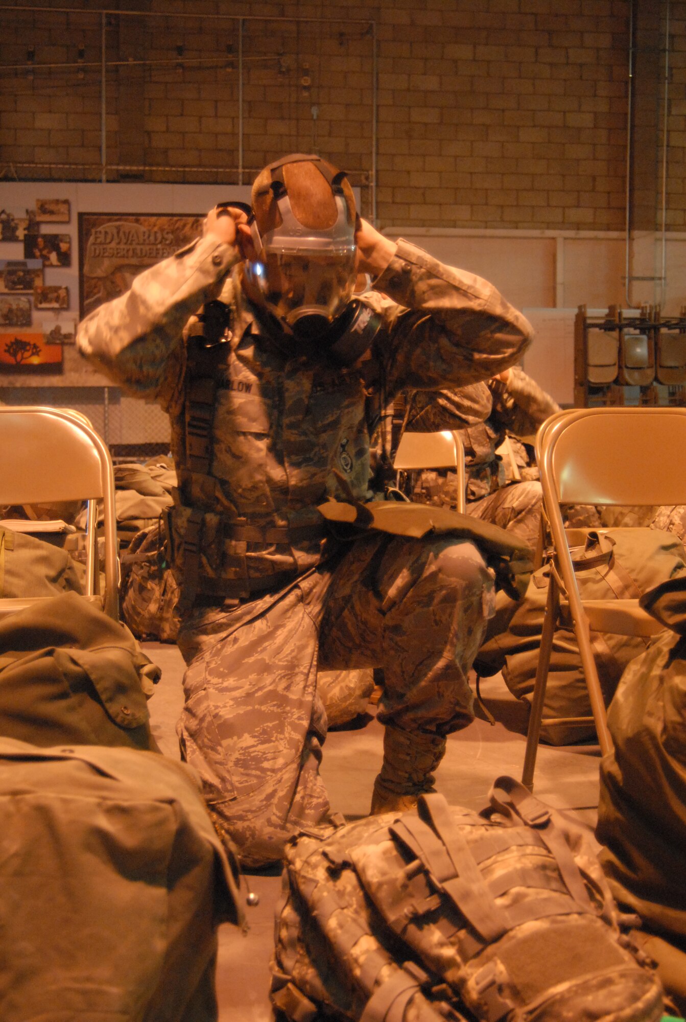 Edwards Airmen practice donning a gas mask for a Chemical, Biological, Radiological and Nuclear training Nov. 22. This is part of the base's Targeted Readiness Inspection training. In addition, Airmen received training on Self-Aid Buddy Care, M-9 and M-16 weapons familiarization, post-attack recognizance and general knowledge on the ability to survive and operate in a deployed location. (Air Force photo by Senior Airman Julius Delos Reyes)