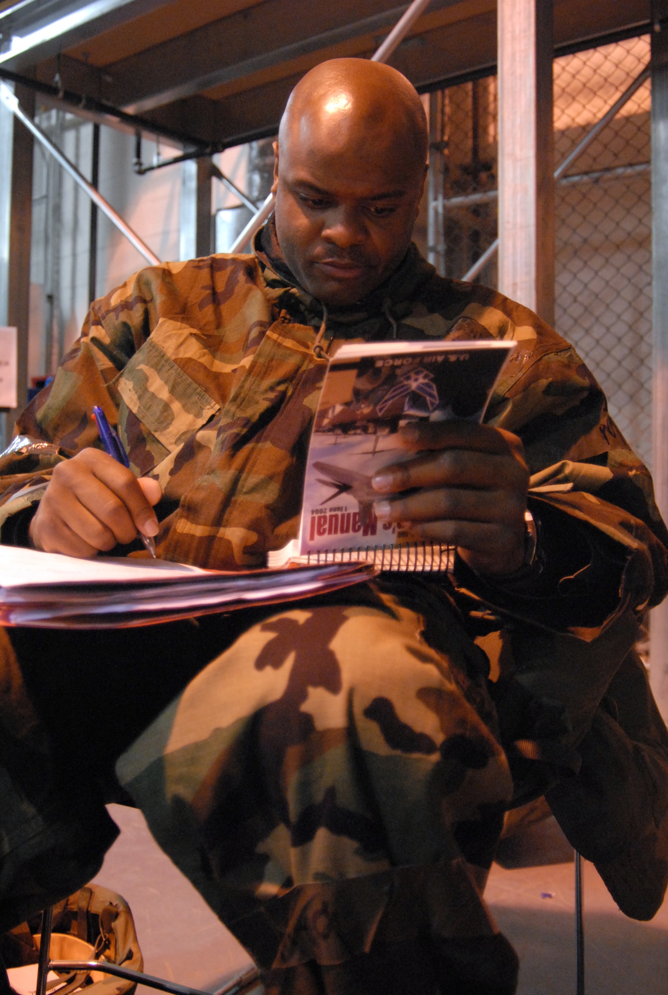 Tech. Sgt. Rondale Alexander, Air Force Flight Test Center noncommissioned officer in charge of information management, reviews his Air Force Manual 10-100 during a Targeted Readiness Inspection training at the Mobility Processing Center Nov. 22. (Air Force photo by Senior Airman Julius Delos Reyes)