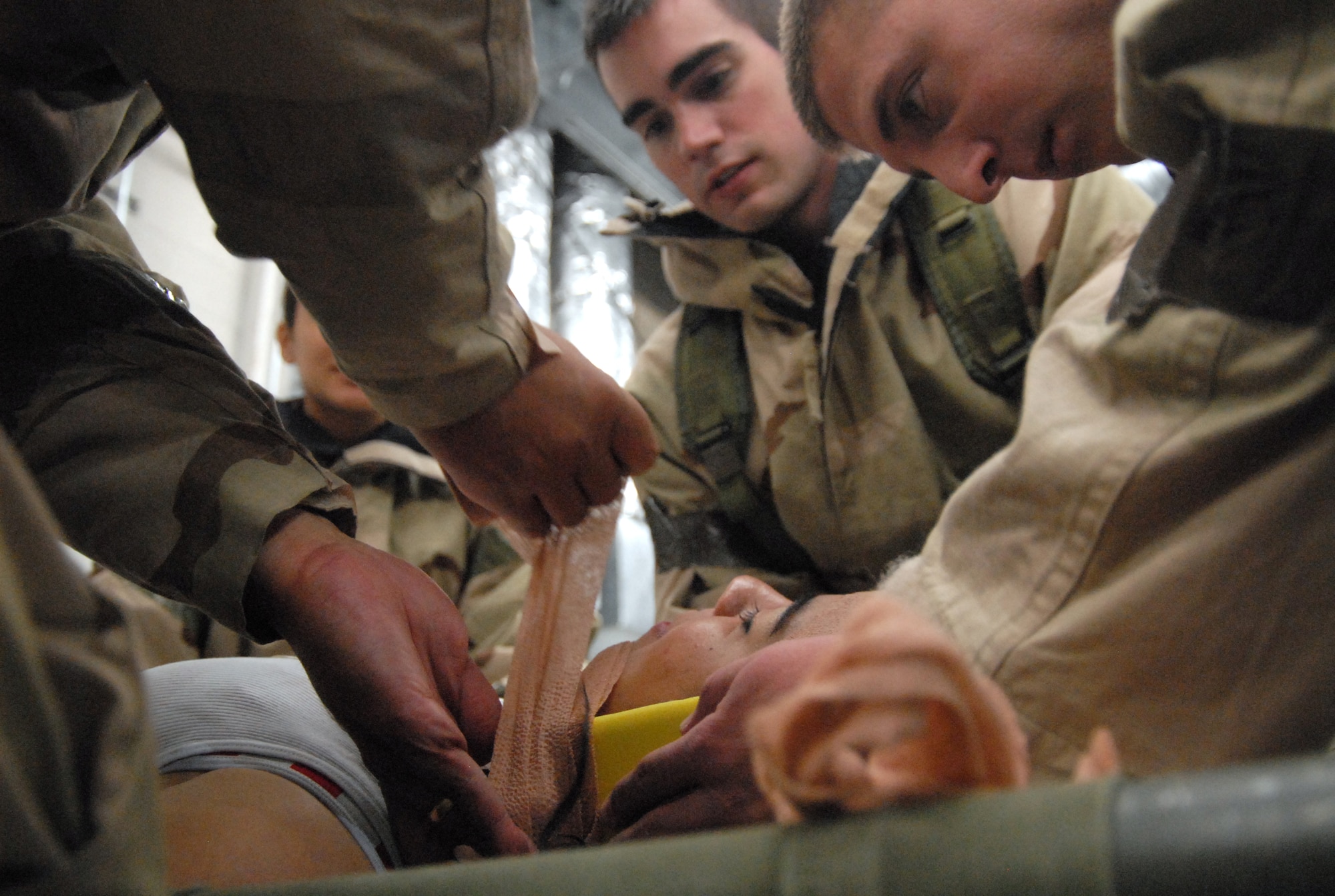 Edwards Airmen "mobilize" the head of an injured victim as part of a Targeted Readiness Inspection training Nov. 22 at the Mobility Processing Center. This is geared towards the base Unit Compliance Inspection in January. Unit Compliance Inspection evaluates areas mandated by law as well as mission areas identified by Air Force and Air Force Materiel Command senior leadership as critical or important to the health and performance of the base. (Air Force photo by Senior Airman Julius Delos Reyes)