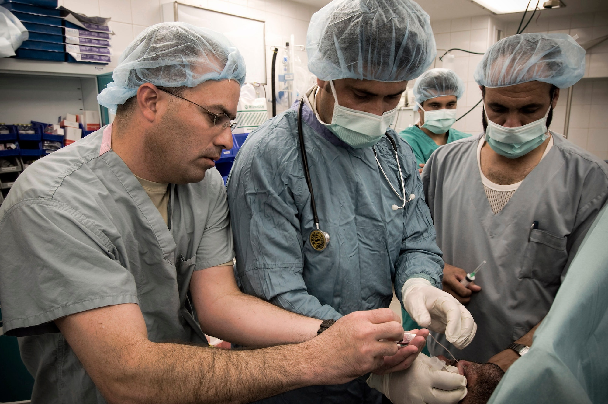 Maj. Elvin Cruz (left) helps Afghan National Army nurse anesthetists prepare a patient for surgery Oct. 27 at the Kandahar Regional Military Hospital in Afghanistan. Major Cruz is deployed from Lackland Air Force Base, Texas, and a native of Arecibo, Puerto Rico. Major Cruz is an anesthesiologist with the 205th Afghan Regional Security Integration Command embedded training team. (U.S. Air Force photo/Staff Sgt. Samuel Morse) 
