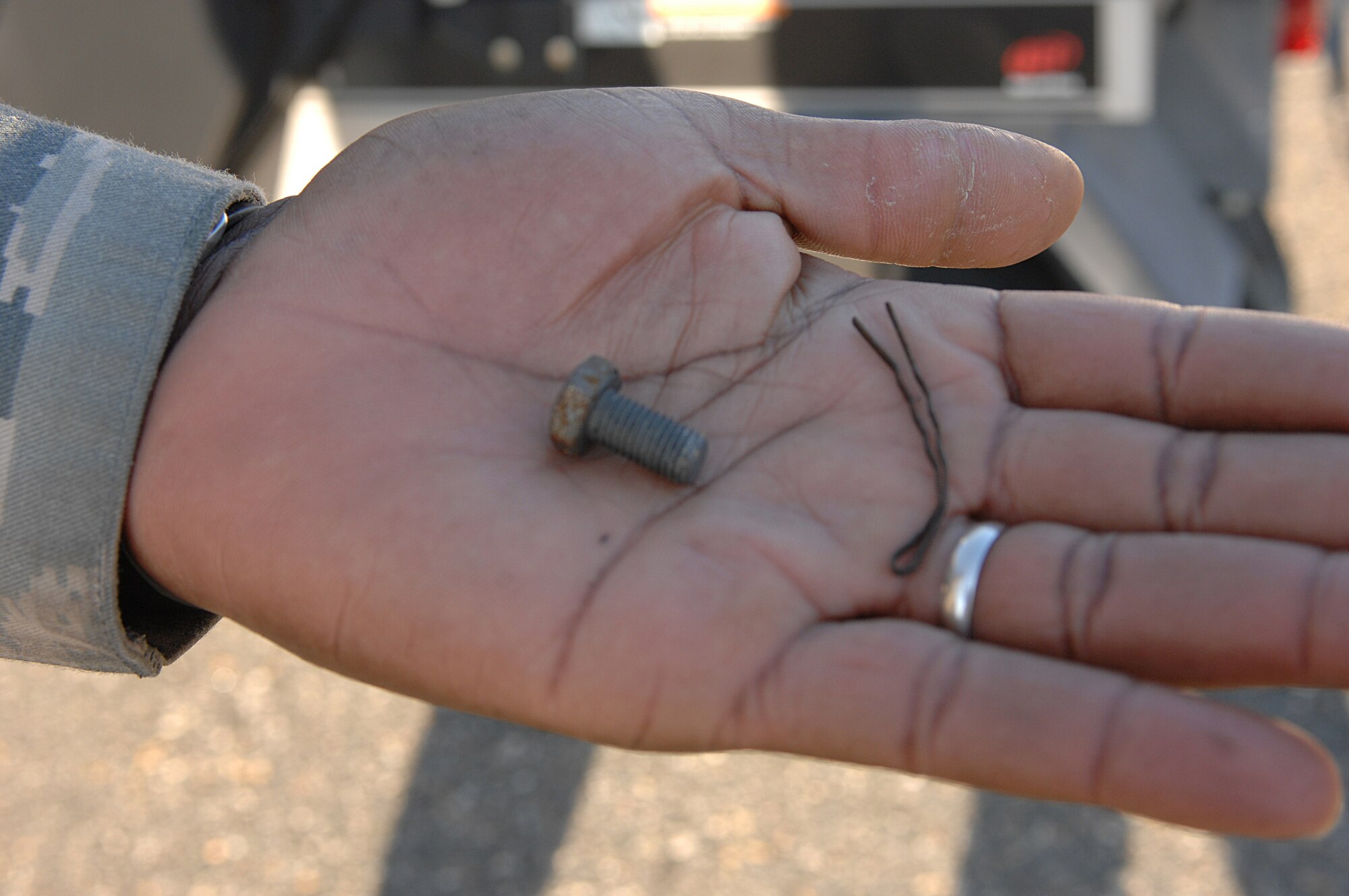 LANGLEY AIR FORCE BASE, Va. – Master Sgt. Duane Gibbs 1st Fighter Wing foreign object damage monitor holds a bolt and hair pin found during a foreign object damage or FOD inspection Nov. 10. An object as small as sand can damage an aircraft engine, according to Sergeant Gibbs. (U.S. Air Force photo/Tech. Sgt. April Wickes)


