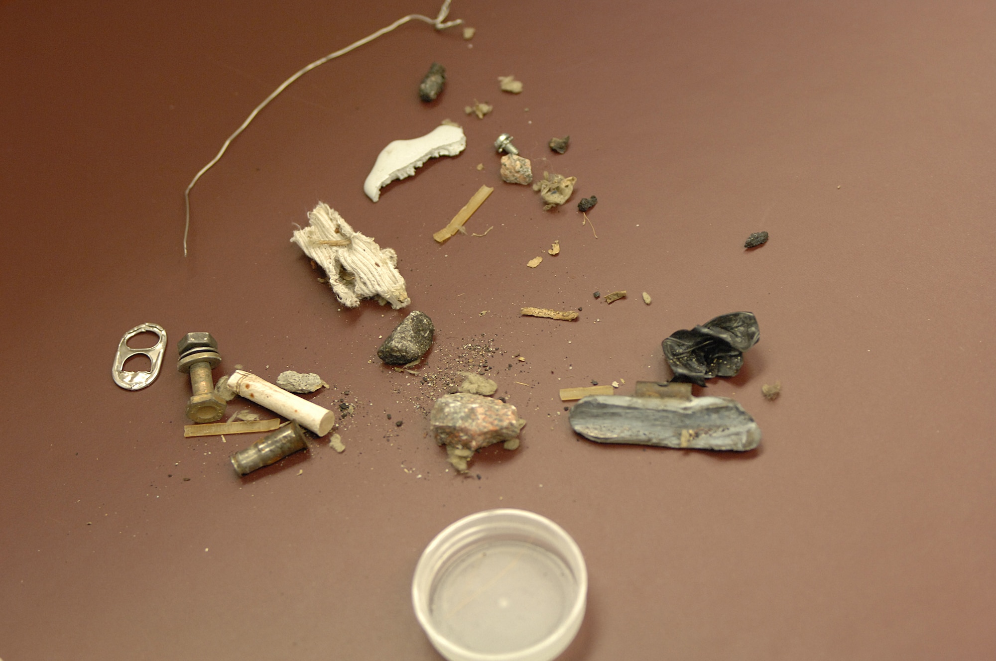 LANGLEY AIR FORCE BASE, Va. – Rocks, bolts, and other objects are picked up during a foreign object damage or FOD walk Nov. 10. FOD is any damage to an aircraft, engine, aircraft system, component, or aircraft ground equipment caused by a foreign object. “FOD prevention helps protect the engines and everything going on the flight line,” said Master Sgt. Michael Bumgardner, 1st Component Maintenance Squadron programs flight chief and FOD monitor. (U.S. Air Force photo/Tech. Sgt. April Wickes)