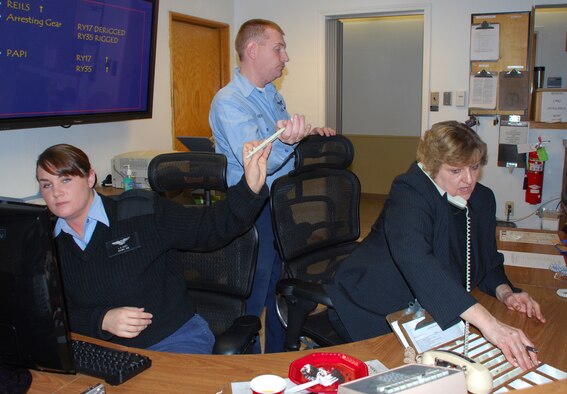 Business as usual just after the ribbon cutting signifying the offical opening of the Joint Air Space Facility. This newest joint venture for NAS JRB Fort Worth combines the Navy and Air Force assests in regards to all incoming and outgoing Air Space requests. Ann Marchione, 301st FW Air Traffic Control specialist, (right) takes receives details on an incoming flight schedule as her Navy counterparts, Petty Officer Genz (center) and Petty Officer 1st Class Lauren Scott, both Air Traffic Control specialists, update flight information.  (U.S. Air Force Photo/Tech. Sgt. Julie Briden-Garcia)