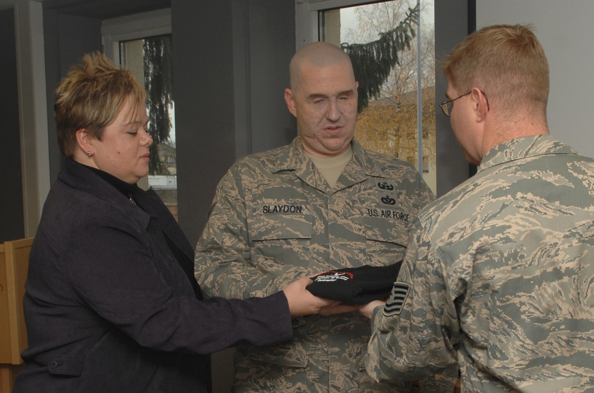 Staff Sgt. Christopher Slaydon and his wife, Annette, receive a t-shirt and a coin from the 52nd Fighter Wing Airman Leadership School at Spangdahlem Air Base, Germany, Nov. 19. Sergeant Slaydon spoke with the ALS class about his accident while he was deployed to Iraq. (U.S. Air Force photo by Airman 1st Class Allen Pollard)