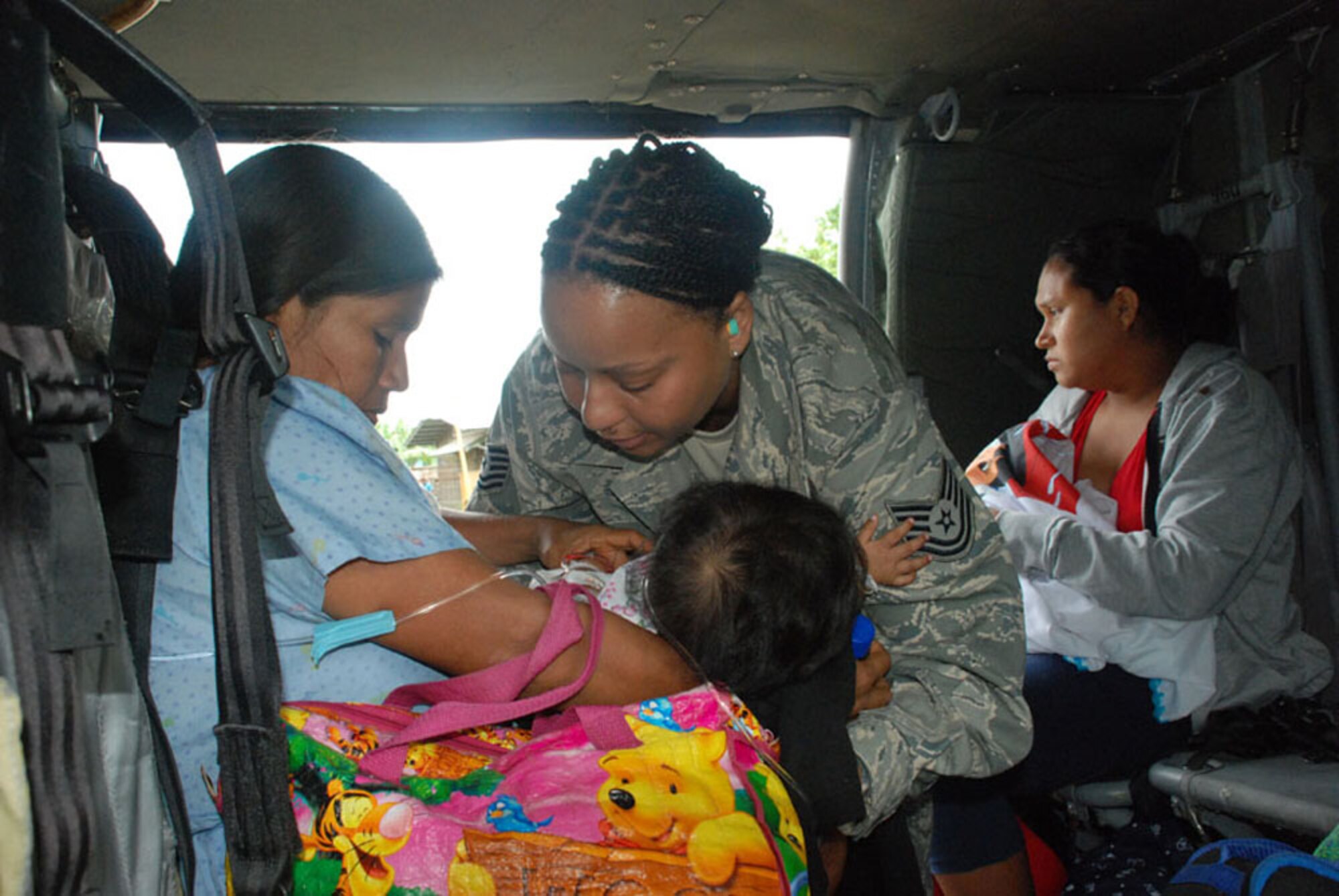 Tech. Sgt. Tracy Fletcher secures a 7-month-old baby and her mother in the seat of a UH-60 Black ?Hawk helicopter Nov. 26 at Las Tablas, Panama. Both were victims of flooding in the region. The baby was suffering ?from severe dehydration, but her mother was unable to take her to a hospital because of flooded ?roads. The Joint Task Force-Bravo helicopter transported the baby and five other patients from a remote ?airfield to an airport where an ambulance met the patients and transported them to a local ?hospital. Sergeant Fletcher is a JTF-Bravo emergency ?medical technician. ??(U.S. Air Force photo/1st Lt. Candace Park)? 

