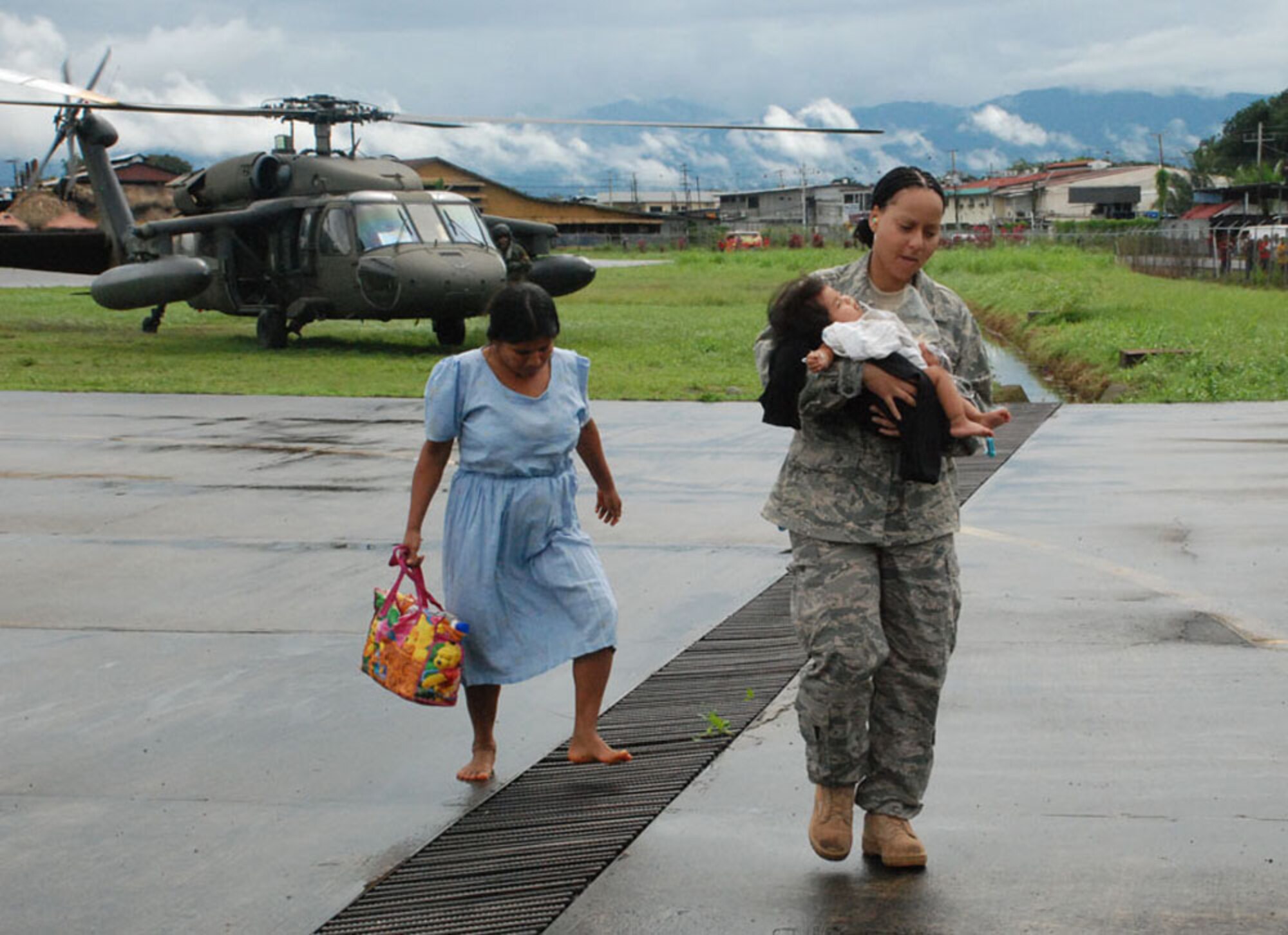 Tech. Sgt. Tracy Fletcher carries a 7-month-old baby from a UH-60 Black Hawk helicopter to an ambulance Nov. 27 at Changuinola, Panama. The baby, suffering from severe dehydration, was transported to a local hospital. Servicemembers from Joint Task Force-Bravo are here in support of a request from the Panamanian government for assistance with recent flooding caused by prolonged heavy rains in the country. Sergeant Fletcher is a JTF-Bravo emergency medical technician. (U.S. Air Force photo/1st Lt. Candace Park)
