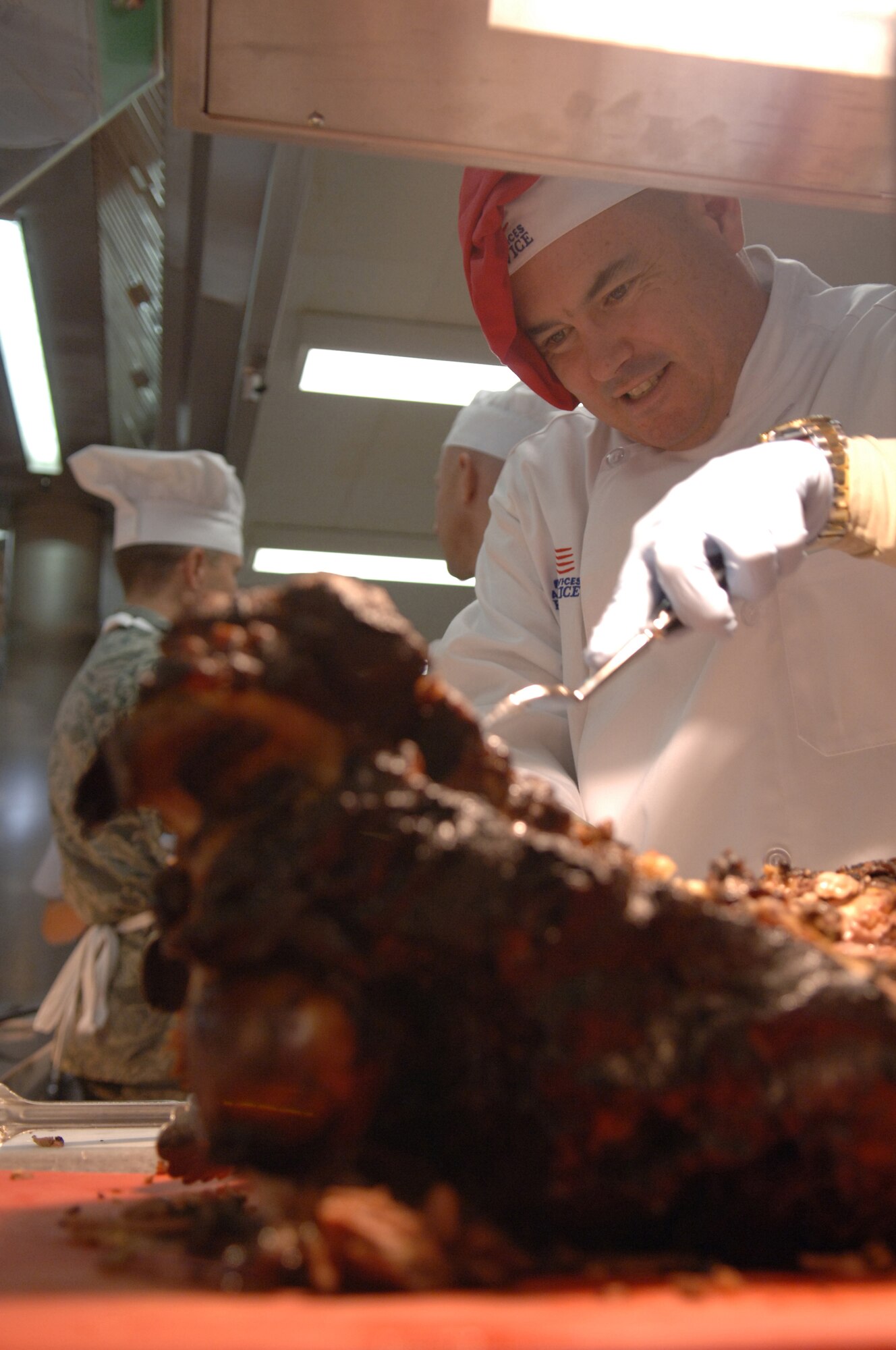 Col. Gus Green (right), 435th Air Base Wing vice commander, carves a roast during Thanksgiving meal to patrons of the Lindberg Hof Dining Facility, Kapaun Air Station, Germany, Nov. 27, 2008. (U.S. Air Force photo by Senior Airman Levi Riendeau)