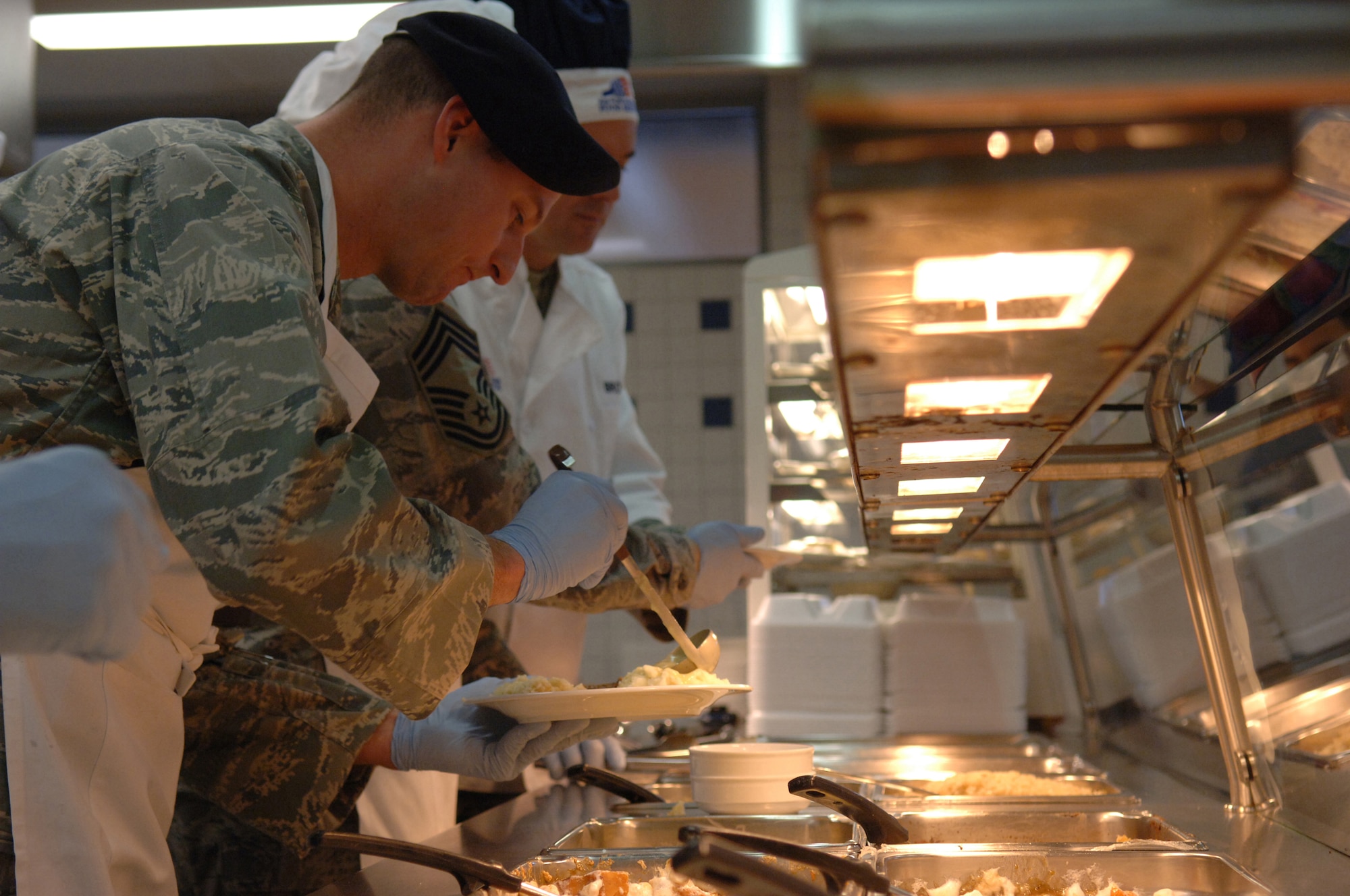 Capt. Justin Secrest, 769th United States Forces Protection Squadron commander, pours gravy on mashed potatoes for a patron of the Lindberg Hof Dining Facility during Thanksgiving meal, Kapaun Air Station, Germany, Nov. 27, 2008. (U.S. Air Force photo by Senior Airman Levi Riendeau)