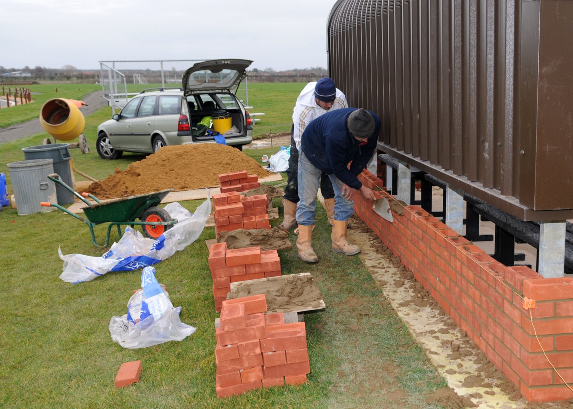 Derek Bradbury and Gary Rush, both contracted bricklayers, lay bricks during the final phase of construction at the softball field behind the Hardstand Gym Nov. 20, 2008, at RAF Milldenhall, England. When completed, the dugouts will provide teams with a place to sit and added protection to the players from the elements. (U.S. Air Force photo by Staff Sgt. Jerry Fleshman)