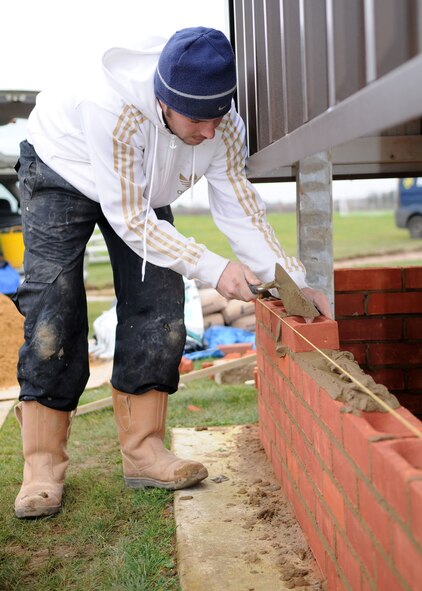 Gary Rush, a contracted bricklayer, puts down a layer of cement during the construction of the new dugouts at the softball field behind the Hardstand Gym Nov. 20, 2008, at RAF Mildenhall, England. When completed, the dugouts will provide teams with a place to sit and give added protection to the players from the elements. (U.S. Air Force photo by Staff Sgt. Jerry Fleshman)