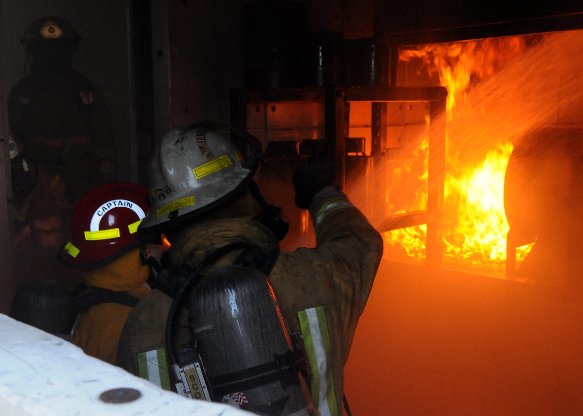 ANDERSEN AIR FORCE BASE, Guam - U.S. Navy firemen extinguish a fire in the "burn room" here Nov. 22 during Fireman 1 and Fireman 2 training. The burn room is used to simulate interior structural fires. (U.S. Air Force photo by Senior Airman Nichelle Griffiths