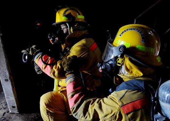 ANDERSEN AIR FORCE BASE, Guam - U.S. Navy Firemen Lenoard Tedtaotao (left) and David Wienert (right) prepare to enter the lower burn room during the live-fire training here Nov. 20. The burn room simulates interior structural fires and is used when conducting annual certification training. (U.S. Air Force photo by Senior Airman Nichelle Griffiths)