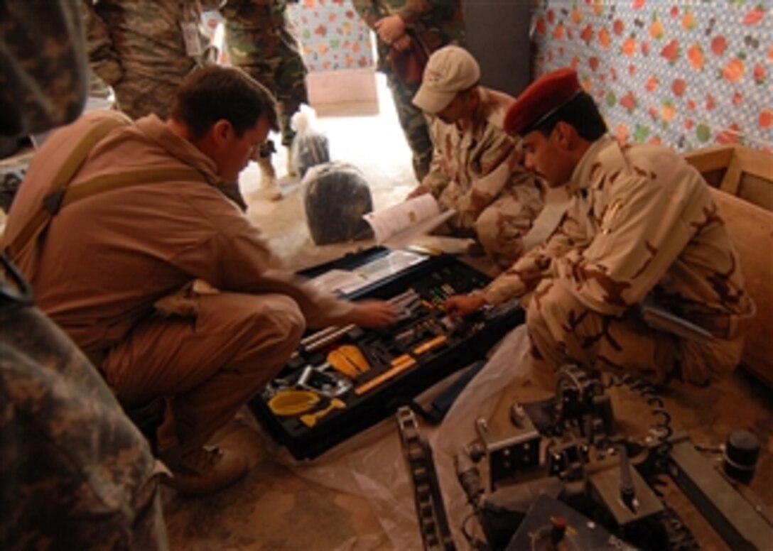 U.S. Navy Lt. Brian Ross, with Explosive Ordnance Disposal Mobile Unit 1, shows Iraqi soldiers assigned to an Iraqi army bomb disposal company how to inspect a hook and line kit in Tikrit, Iraq, on Nov. 26, 2008.  