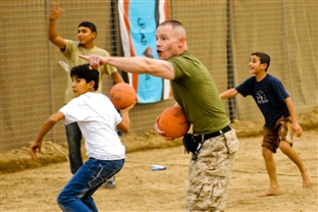 U.S. Marine Corps Gunnery Sgt. Kevin Weintraub points to a boy who was hit "out" during a dodge ball game at a troop scout meeting in southern Baghdad, Iraq, Nov. 22, 2008. Weintraub is assigned to Multinational Force Iraq as a foreign disclosure officer.