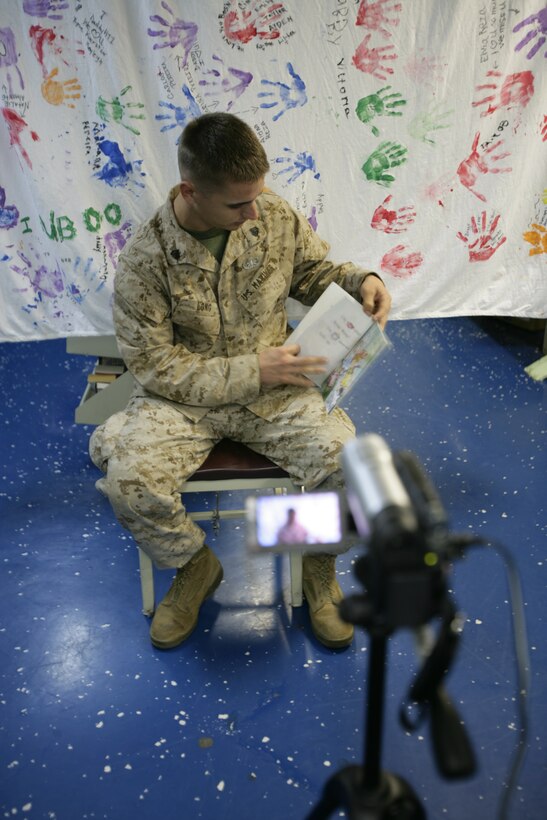 Sgt Curtis A. Long turns a page while recording a children's story through the United Through Reading Program.::r::::n::"I use United Through Reading to stay connected with my kids," said Long, an Explosive Ordnance Disposal technician with Combat Logistics Battalion-26, the CLB for the 26th MEU.  "Being in EOD, I am gone a lot of the time even in between deployments.  This way my daughters know that I still care about them.  It helps keep that family bond," he said.