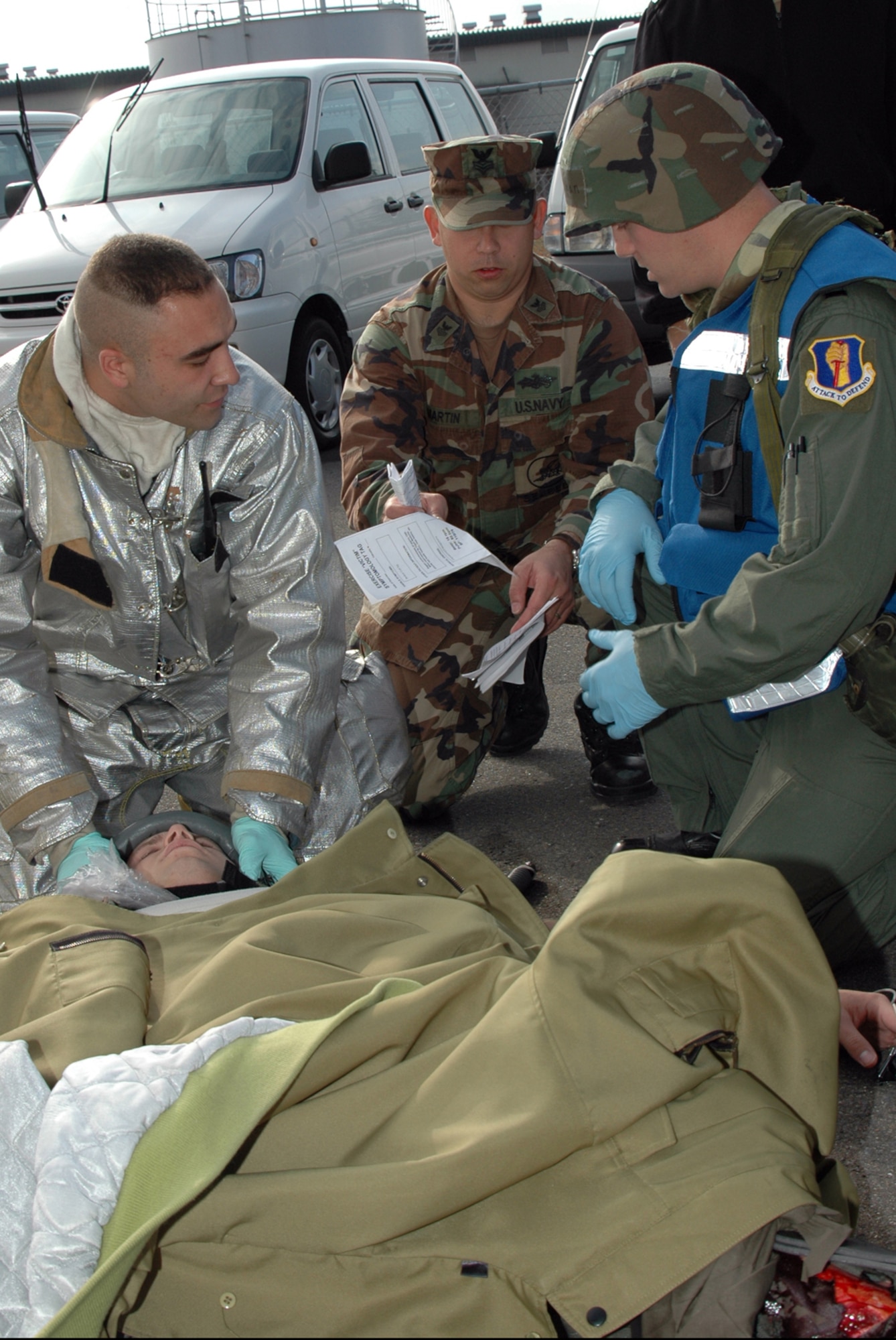 MISAWA AIR BASE, Japan -- Senior Airman Sean Willeford, 35th Civil Engineer Squadron, and Petty Officer 1st Class Clifford Martin, Naval Air Facility Misawa, discuss the condition of a simulated downed aviator with flight surgeon, Capt. Anthony Eschliman, 35th Aerospace Medicine Squadron Nov. 17, 2008. The scene was part of an exercise held in conjunction with a triennial Air Force Unit Compliance Inspection. Though Air Force units were the focus of the inspection team, personnel and assets from the Naval Air Facility played supporting roles. (U.S. Navy photo by Chief Petty Officer Brian Naranjo)