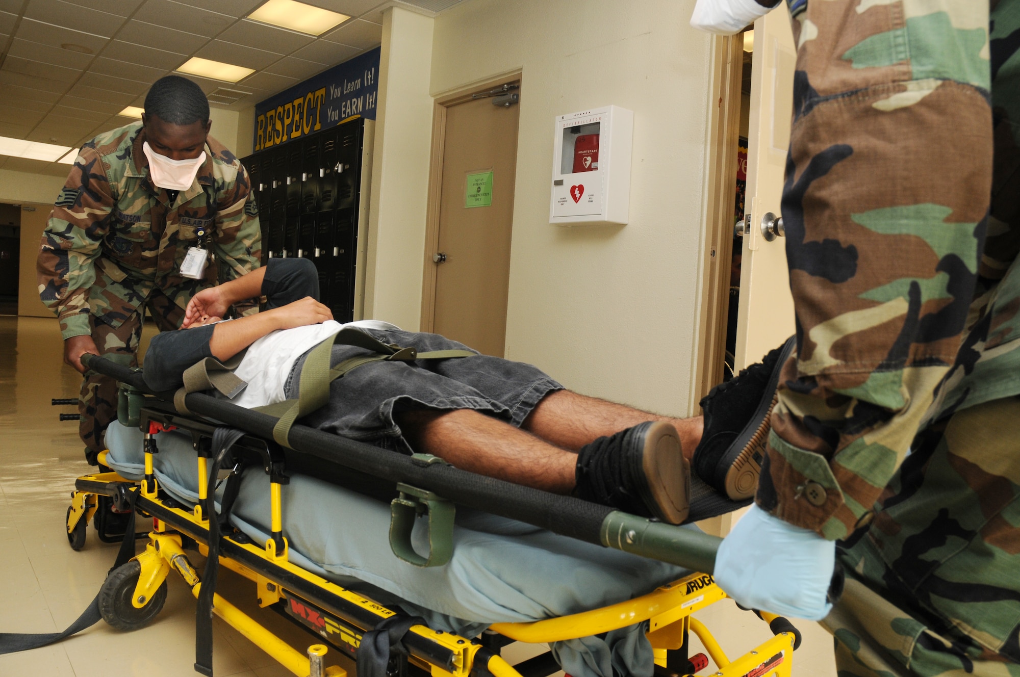 Airmen from the 18th Medical Group lift a Kadena High School student onto a stretcher following a simulated contamination of the high school's food supply during a Local Operational Readiness Exercise at Kadena Air Base, Japan  Dec. 02, 2008. The simulation is part of a Local Operational Readiness Exercise meant to test the operational readiness of Kadena Airmen. 
(U.S. Air Force photo/Airman 1st Class Chad Warren)