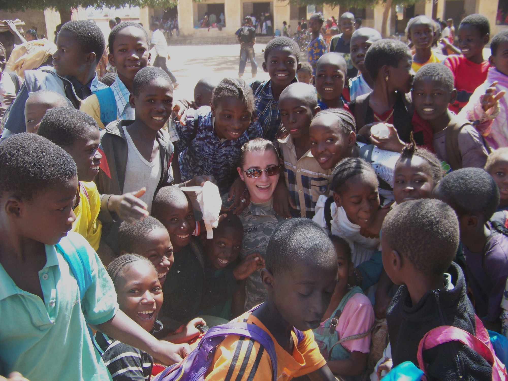 1st Lt. Lauren Johnson is surrounded by a group of African children recently at a school outside the airport in Bamako, Mali. Lt. Johnson was in Africa supporting FLINTLOCK, a training exercise featuring the United States and 15 African and Partner Nations designed to increase security and build capacity in the Trans-Saharan region. (U.S. Air Force photo/1st Lt. Jon Saas)