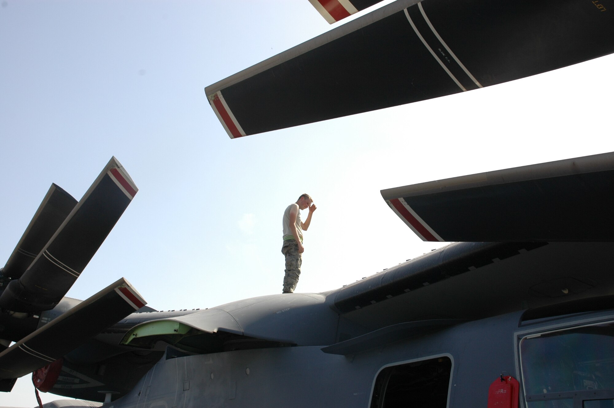 An Airman from the  1st Special Operations Helicopter Maintenance Squadron works atop a CV-22 Osprey under the African sun in Bamako, Mali recently. The CV-22s conducted their first operational deployment as part of FLINTLOCK, a training designed build capacity among Trans-Saharan nations so that they may more effectively address issues which threaten peace, stability and security. (U.S. Air Force photo/1st Lt. Lauren Johnson) 