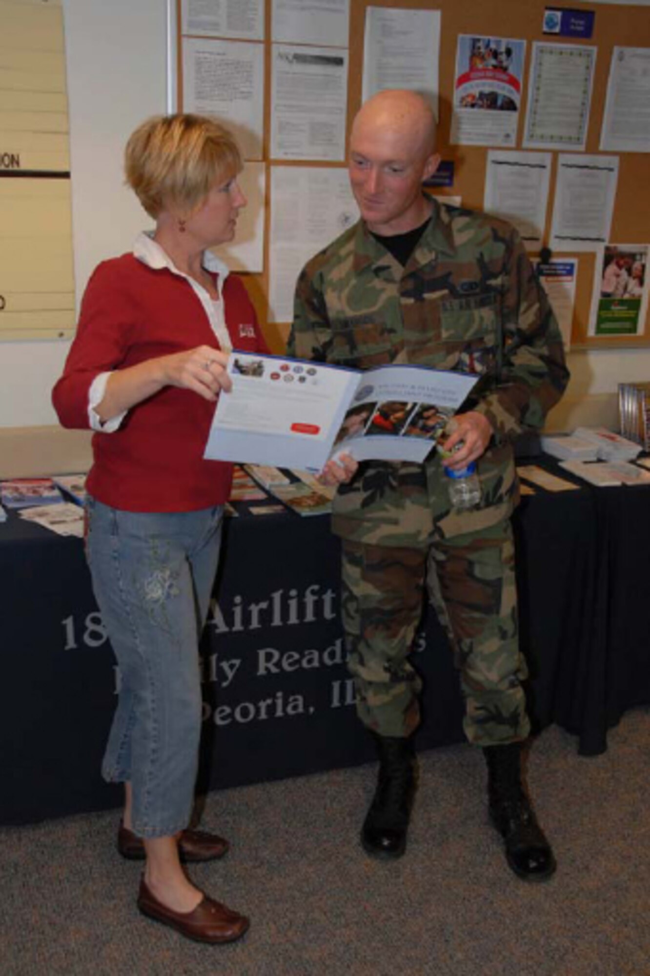 Susan Webb, President of the 182nd Airlift Wing Family Readiness Group, discusses some resources available to military members and their families to Senior Airman Scott Swanson, from the Communications Flight. Photo by Tech. Sgt. Shane Hill