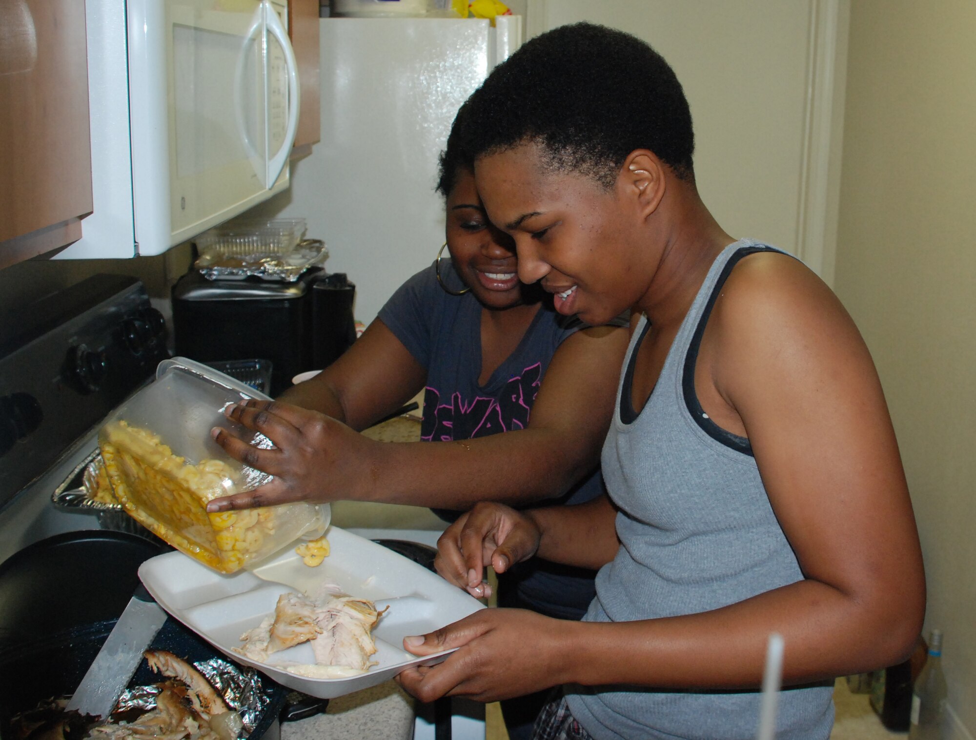 Airmen 1st Class Ashlee McClease and Airman 1st Class Leslee Lusk, permanent party Airmen, provide a Thanksgiving meal in a home environment for Airmen in Training during Operation Thanksgiving Nov. 27. Operation Thanksgiving provided 536 AiT the opportunity to get to know the community outside of Sheppard. (U.S. Air Force photo/Airman 1st Class Candy Miller) 