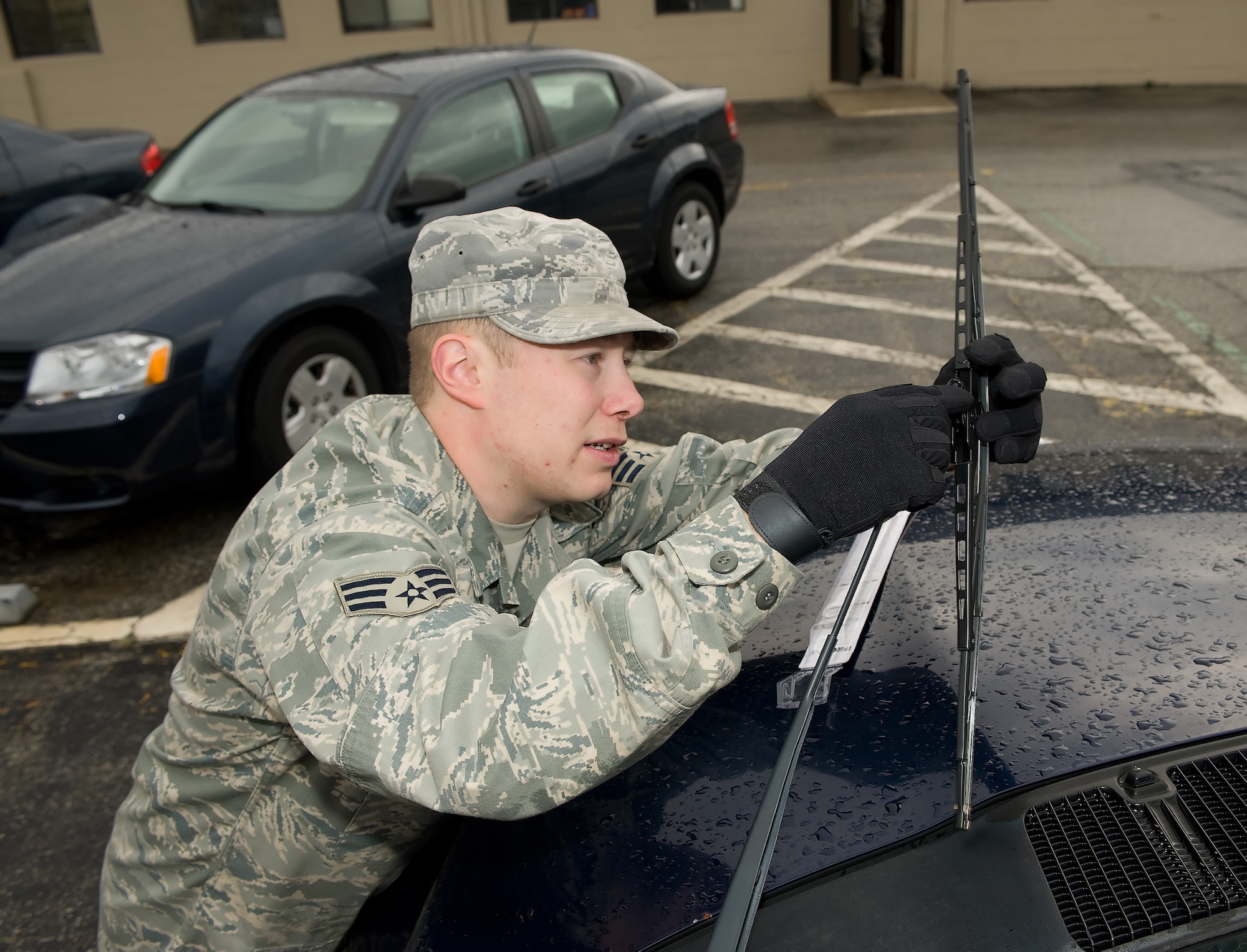 Senior Airman Jason Biehl, 436th Logistics Readiness Squadron assistant NCOIC of equipment support, inspects the windshield wipers on a government vehicle.  The National Safety Council recommends checking wipers for damage during the winter months and that drivers keep an emergency kit in their trunk with a spare tire, jack, jumper cables, bag of salt or cat litter, and a tool kit.  (U.S. Air Force photo/Jason Minto)