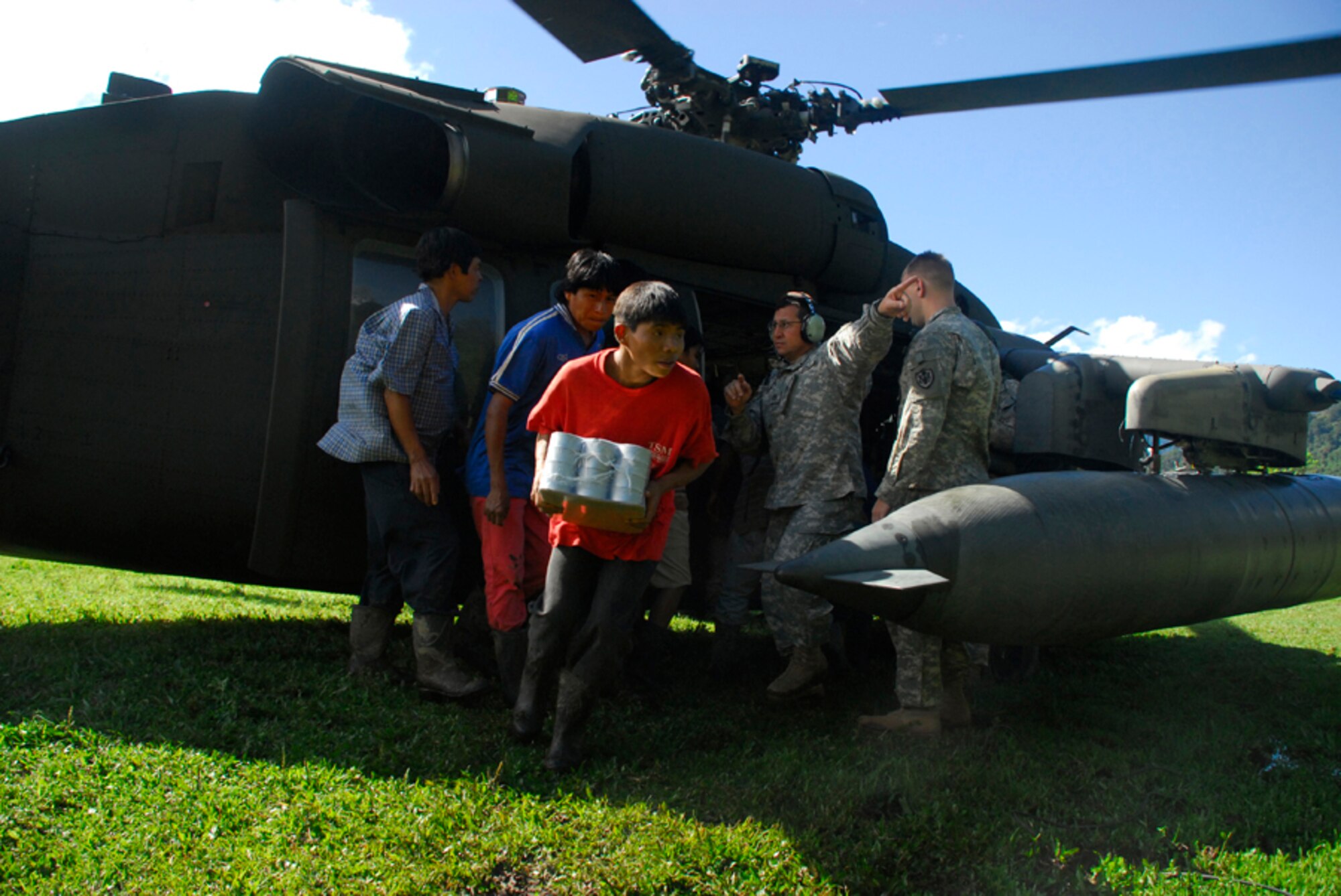 Army Staff Sgt. Samuel Colon directs locals from a remote village in Costa Rica where to pick up food from the Blackhawk helicopter Dec. 1. (U.S. Air Force photo by Staff Sgt. Joel Mease)
