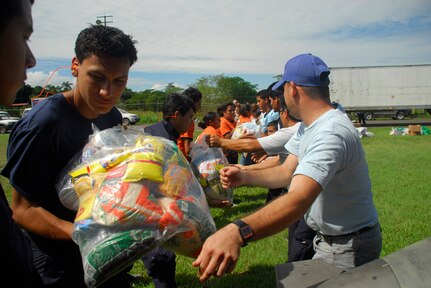 Members from the Costa Rican National Emergency Commision and Red Cross form a chain to load food onto a Blackhawk helicopter Dec. 1. More than 69,000 pounds of food and supplies had been delivered by Nov. 30. (U.S. Air Force photo by Staff Sgt. Joel Mease)