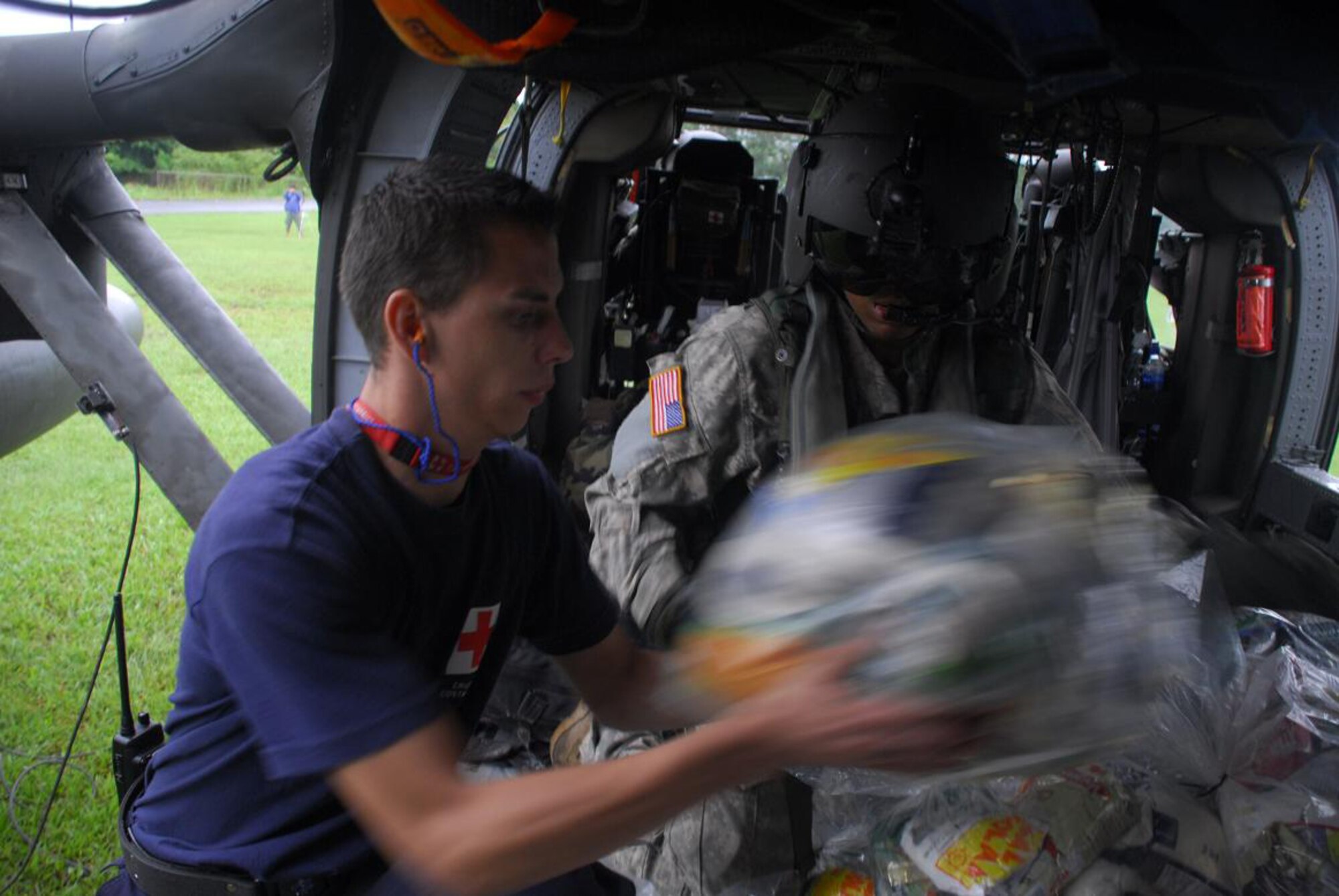Army Specialist Robert Hunt, Joint Task Force-Bravo crew chief, assists a member of the Costa Rica Red Cross load food onto a Blackhawk Nov. 30. (U.S. Air Force photo by Staff Sgt. Joel Mease)