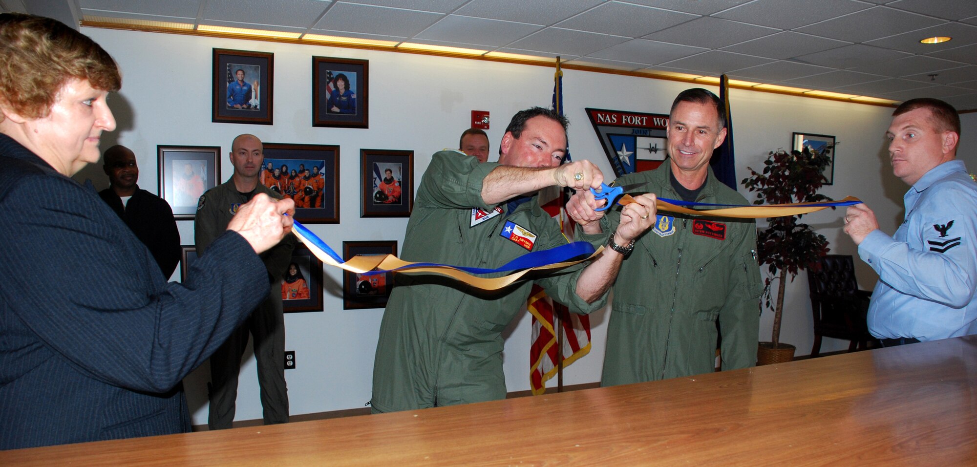 Navy Capt. T.D. Smyers, Naval Air Station Joint Reserve Base Fort Worth skipper, (center left), assists Col. Kevin Pottinger, 301st Fighter Wing commander, in a ribbon cutting signifying the offical opening of the Joint Air Space Facility. This newest joint venture for NAS JRB Fort Worth combines the Navy and Air Force assests for all incoming and outgoing Air Space requests. Ann Marchione, 301st FW Air Traffic Control specialist, holds the left end of the ribbon with Navy counterpart, Petty Officer 2nd Class Genz holding the right. (U.S. Air Force Photo/Tech. Sgt. Julie Briden-Garcia)