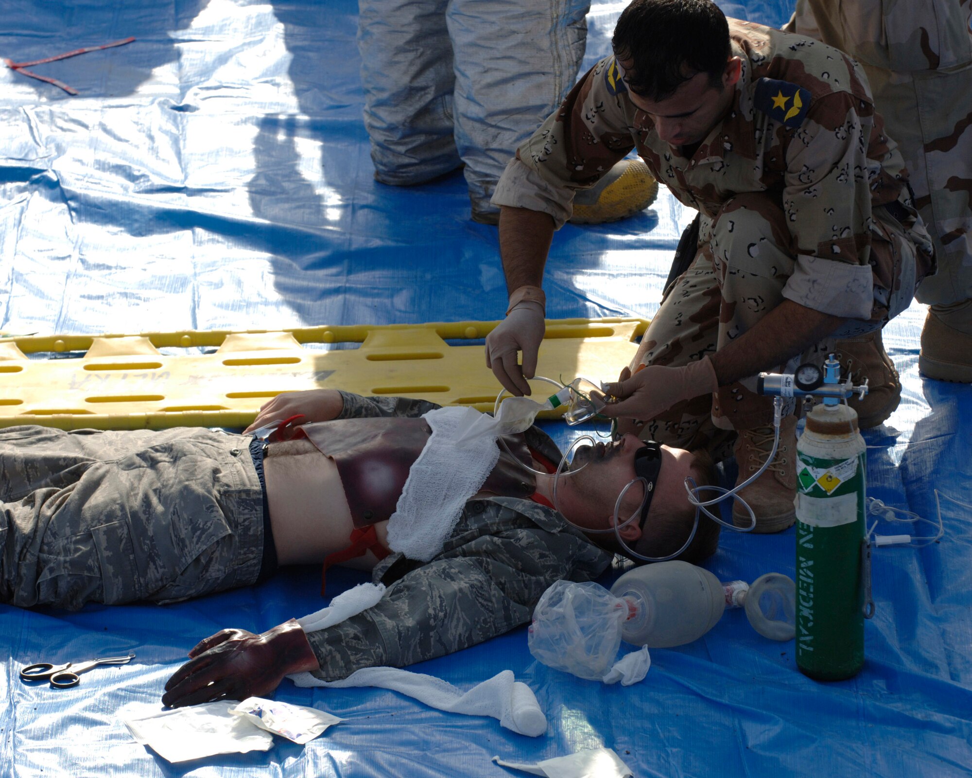 An Iraqi medic gives oxygen to a U.S. Airman mock casualty during a major accident response exercise Nov. 21 at New Al-Muthana Air Base, Iraq. The exercise tests the abilities of a joint response of fire rescue, medical and security capabilities. (U.S. Air Force photo/Staff Sgt. Paul Villanueva II) 
