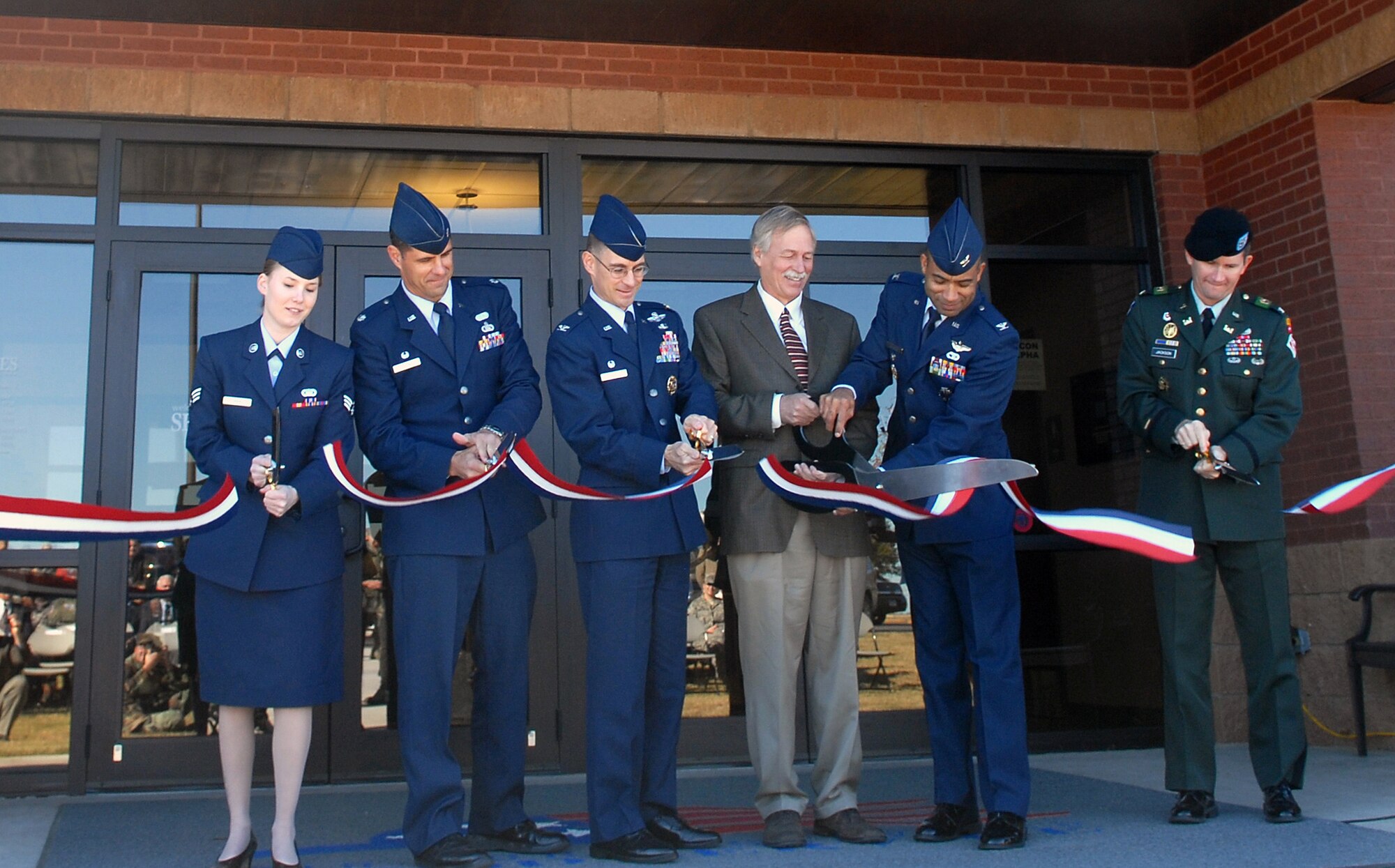 Senior Airman Theresa Davis, 19th Airlift Wing, acting president for the Airman's council, Lt. Col. Jeffrey Collins, 19th Services Squadron commander, Col. C.K. Hyde, 314th Airlift Wing commadner, Congressman Vic Snyder, Col. James Johnson, vice commander 19th Airlift Wing and U.S. Army Col. Donald Jackson Army Corps of Engineers district engineer and commander cut the ribbon at the Hercules Dining Facility grand opening Nov. 7. (U.S. Air Force photo by Staff Sgt. Chris Willis)