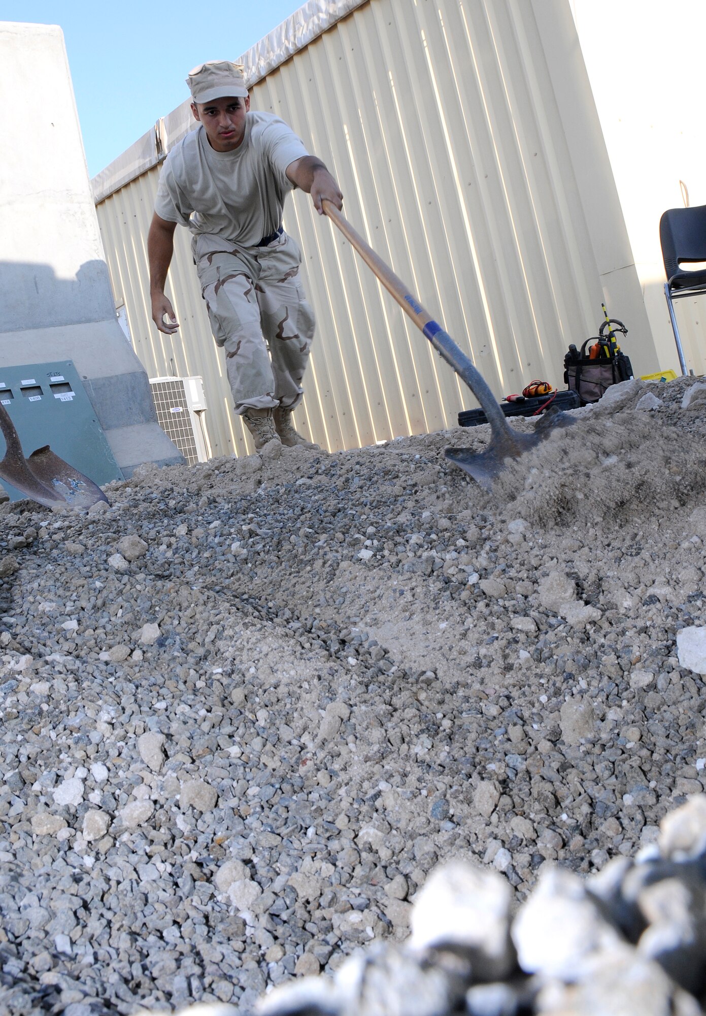 SOUTHWEST ASIA -- Airman 1st Class Carlos Suarez from the 380th Expeditionary Civil Engineer Squadron shovels final grade here Nov. 25. He is replacing the dirt from a trench dug to get to feeder circuits. The electric shop had to get to the circuits to provide electricity to a new ECS building. Airman Suarez is deployed from the 735th CES Ramstein Air Base, Germany; his hometown is Honolulu, Hawaii. (U.S. Air Force photo/Tech. Sgt. Christopher A. Campbell)(released)