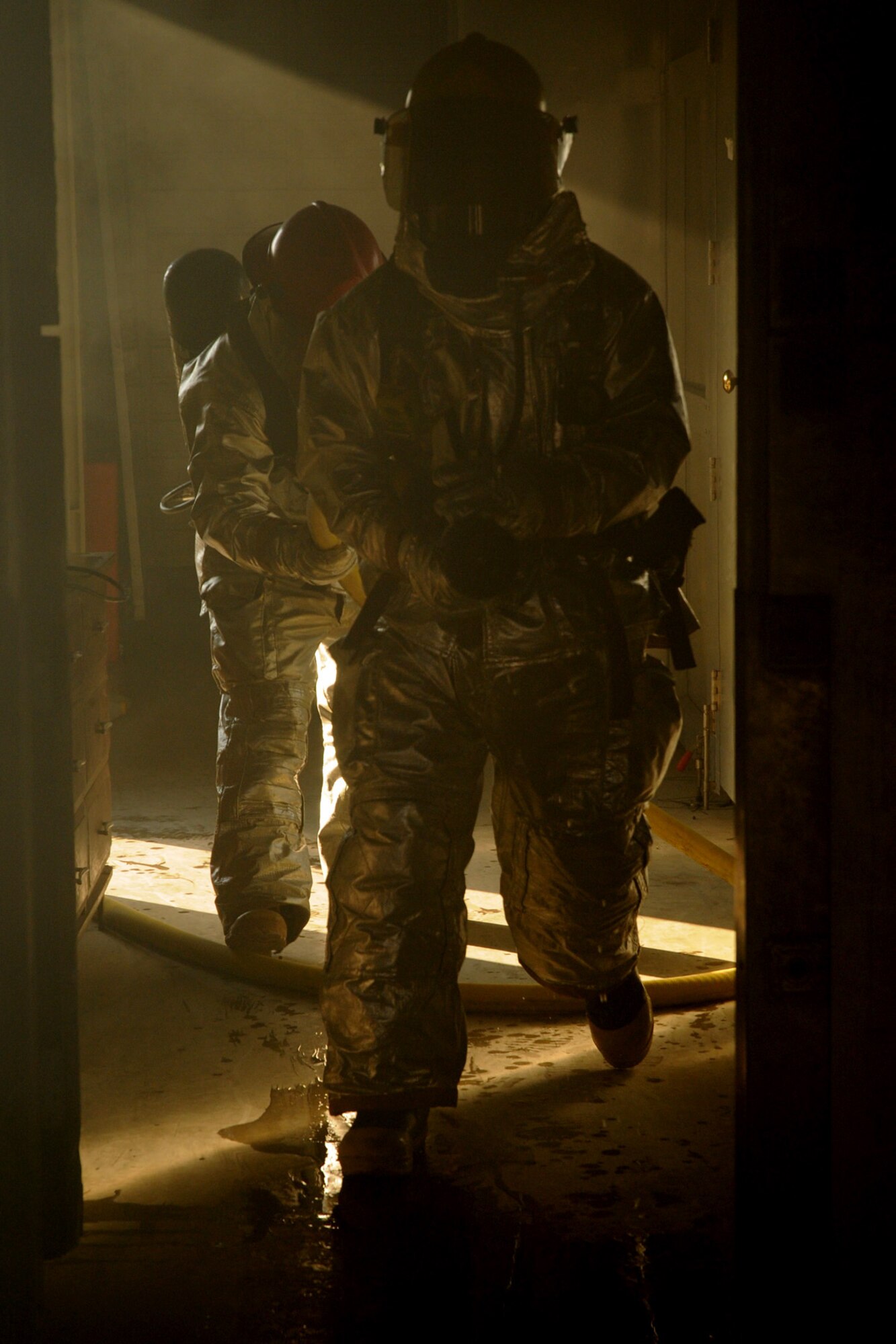 Airman 1st Class Vincent Kinard (front) and Staff Sgt. John Garcia, 18th Civil Engineering Squadron Fire Department, enter a smoke-filled room for a simulated kitchen scenario at the Silver Flag Training Facility Dec. 2 at Kadena Air Base. The 18th Wing is participating in a Local Operational Readiness Exercise to test the readiness of Kadena Airmen. (U.S. Air Force photo/Airman 1st Class Amanda Grabiec)