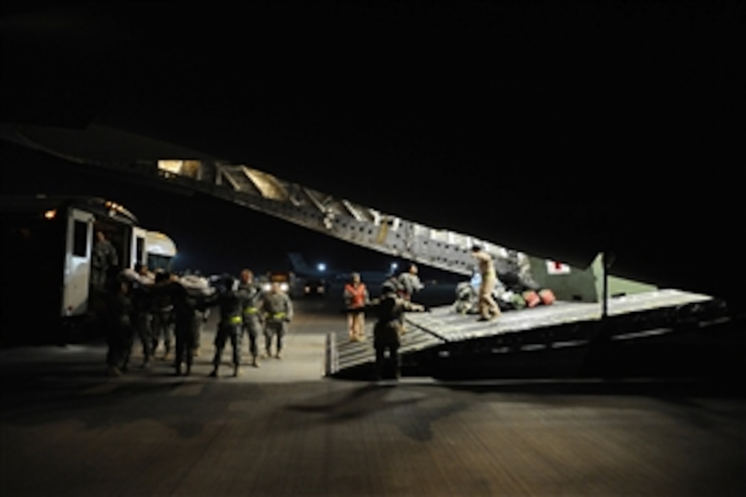 Volunteers and medical staff load a litter-bound patient from a Contingency Aeromedical Staging Facility ambulance bus onto a C-17 Globemaster III aircraft before aeromedical evacuation out of Joint Base Balad, Iraq, on Nov. 27, 2008.  