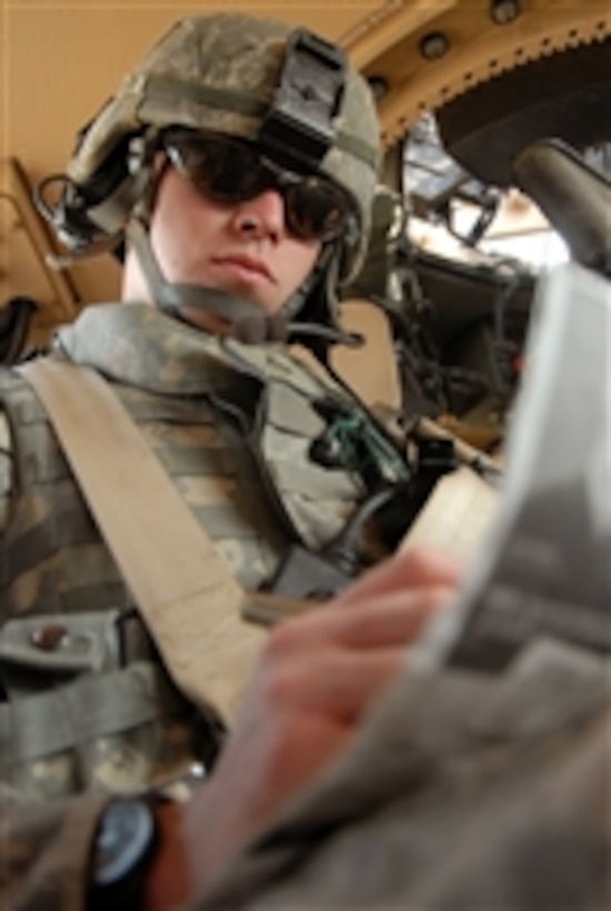 U.S. Army Pfc. Justin Fisher, of Charlie Troop, 1st Battalion, 10th Calvary Regiment, 2nd Brigade Combat Team, 4th Infantry Division, writes down notes following a visit to the Central Euphrates Farmers Market in Haswah, Iraq, on Nov. 28, 2008.  