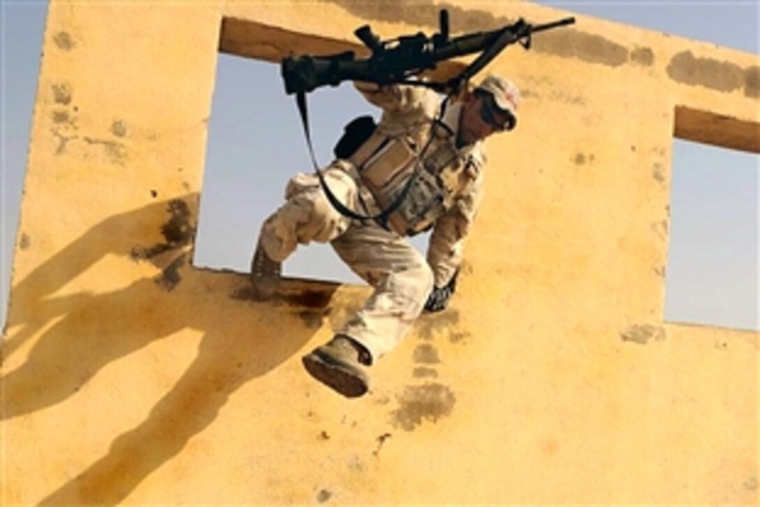 An Iraqi soldier clears an obstacle as he works his way toward a simulated casualty during medical training with U.S. Army Special Forces soldiers on Camp Diwaniyah, Iraq, Dec. 1, 2008. The Iraqi soldiers ran the obstacle course before evaluating their casualty in order to test their performance under stressful conditions.