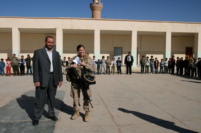 Muthana Jubaer Juwana, the president of the Rutbah, Iraq, City Council, and Petty Officer 2nd Class Bridget Shanahan, a Navy reservist and corpsman with Shock Trauma Platoon, 2nd Combat Logistics Battalion, speak to first and second grade students at a primary school in Rutbah Dec. 2.  Shanahan, 23, is a junior at Pierce College in Woodland Hills, Calif. ::r::::n::
