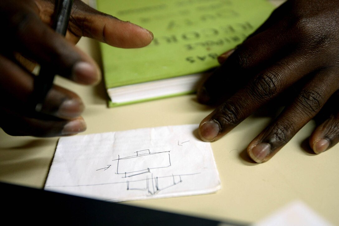 George Akwei Mingle, a Ghanaian-born corpsman with Task Force 3rd Battalion, 7th Marine Regiment, Regimental Combat Team 5, practices his architectural drawing at Combat Outpost Rawah, Iraq, Dec. 4.  Mingle, who moved to Alexandria, Va. after finishing his bachelor's degree in Ghana, hopes to eventually become an officer in the Seabees and pursue his true passion in life and become an architect.::r::::n::